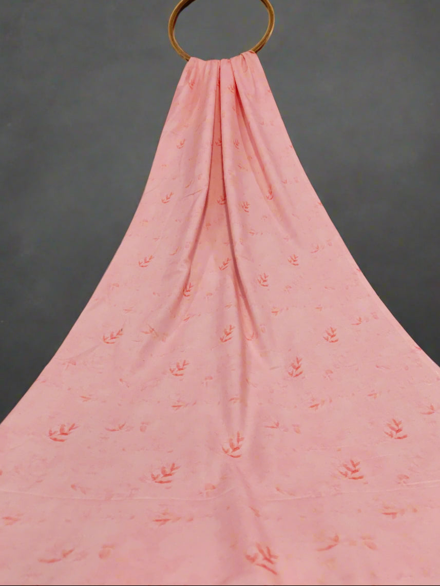 Pink fabric with subtle pattern draped over a red curtain