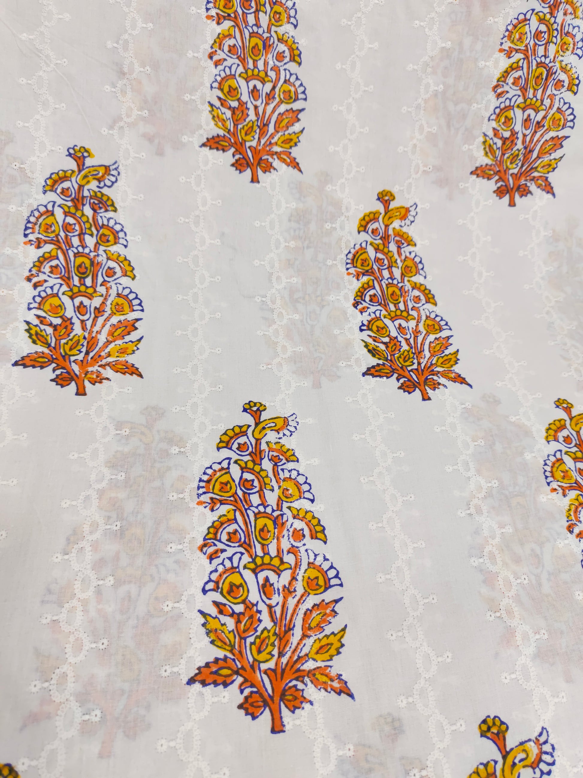 White embroidered fabric with orange handblock print