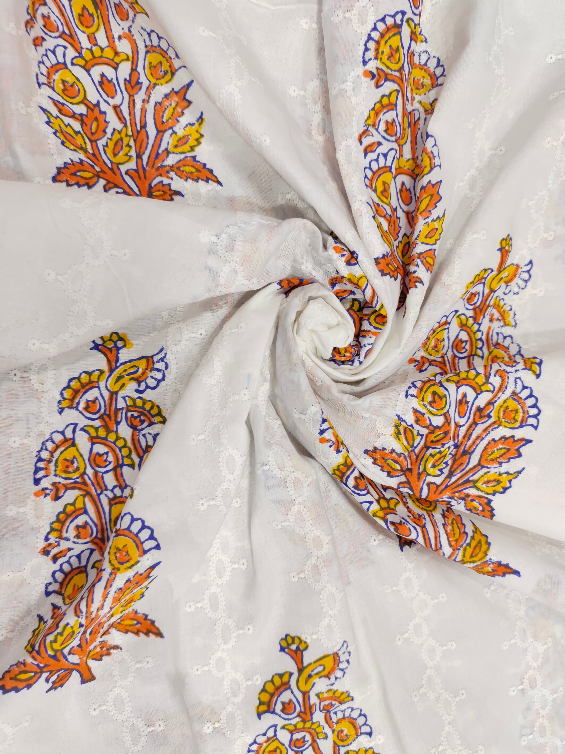 White embroidered fabric with orange handblock print