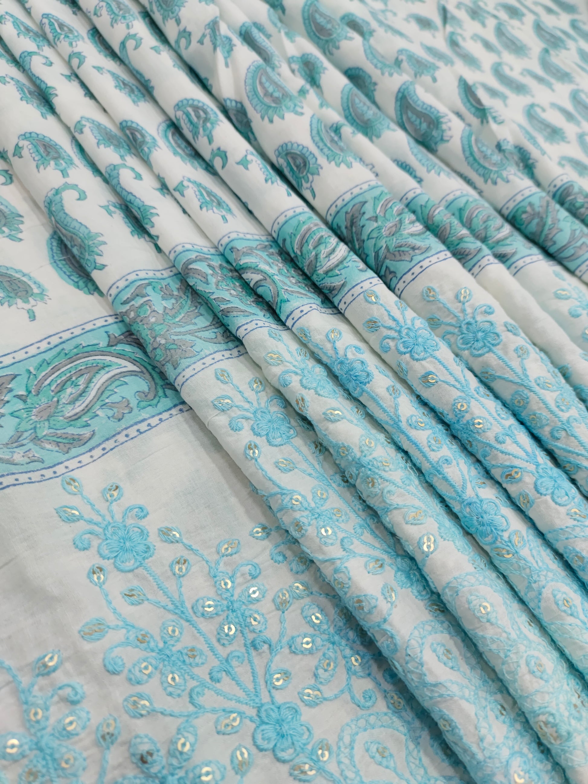 White fabric with blue handblock print and added with schiffli daman