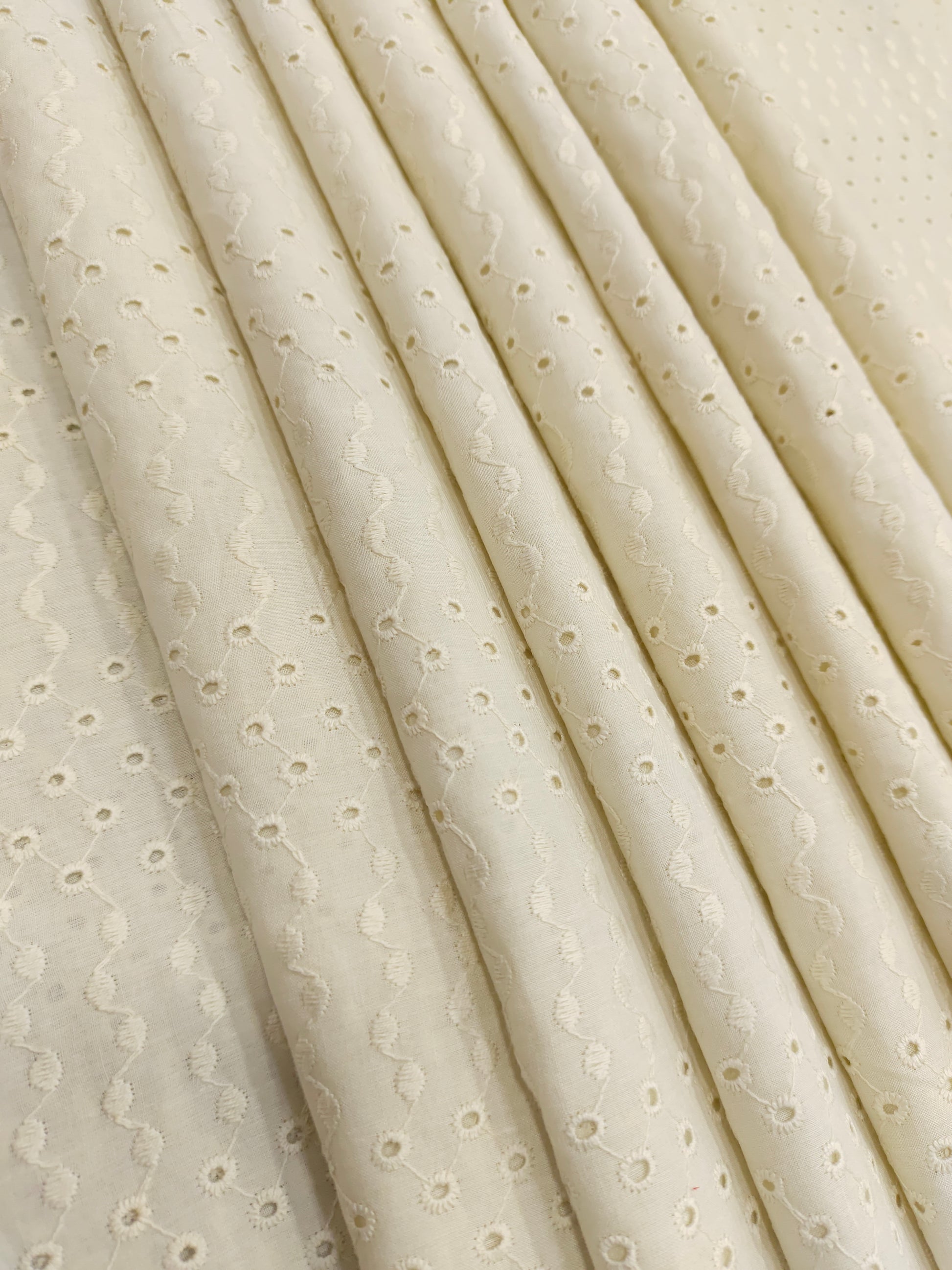 Off white embroidered fabric with small holes