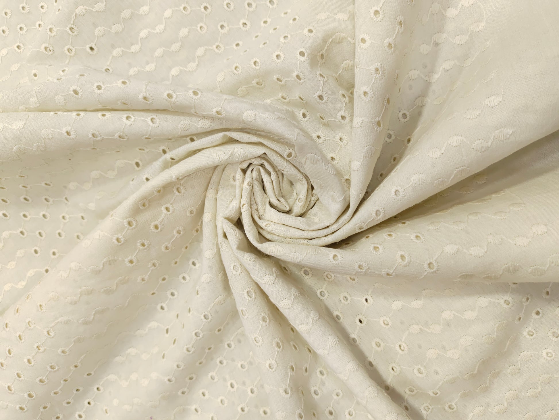 Off white embroidered fabric with small holes