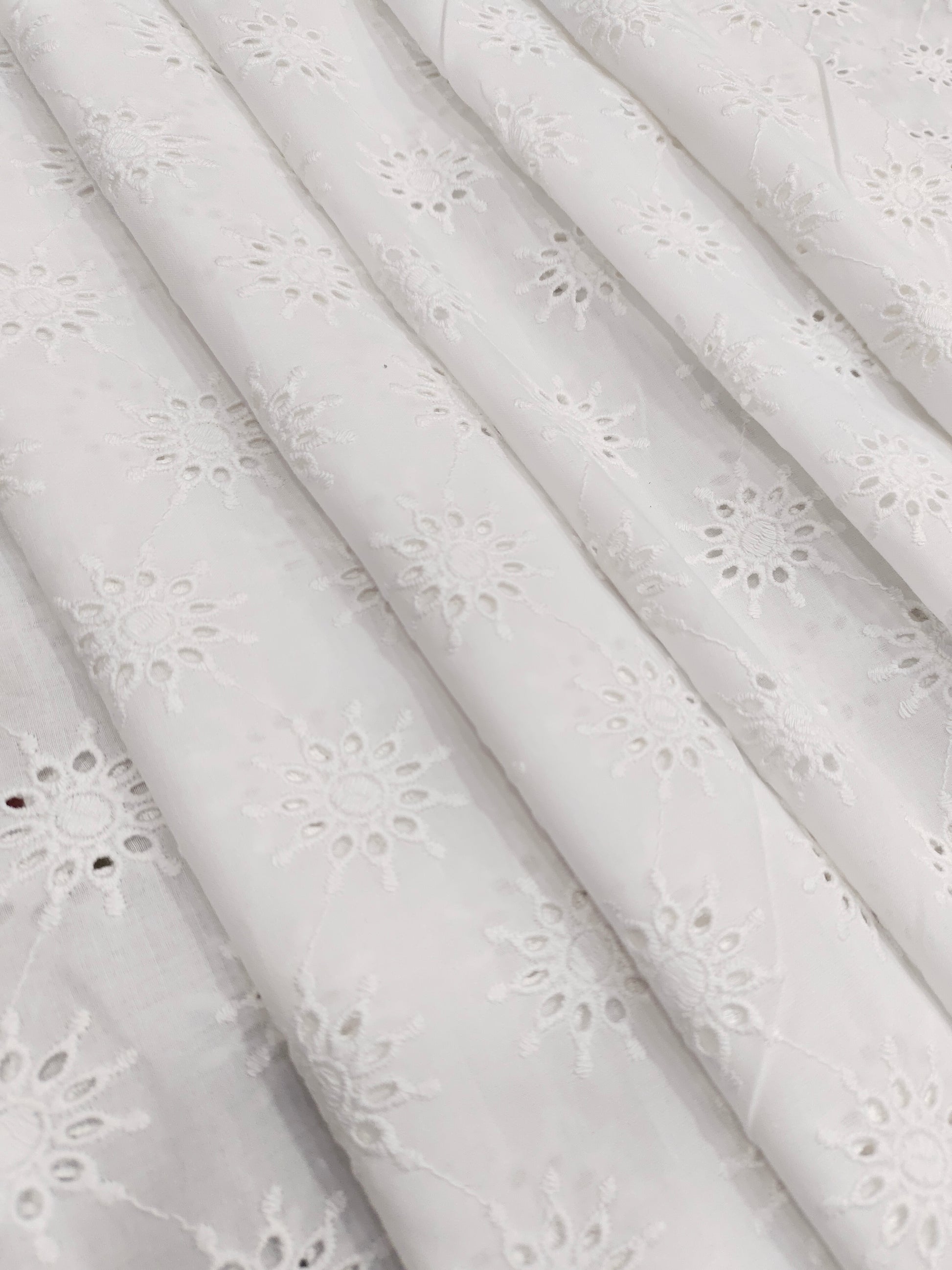 White embroidered cutwork fabric