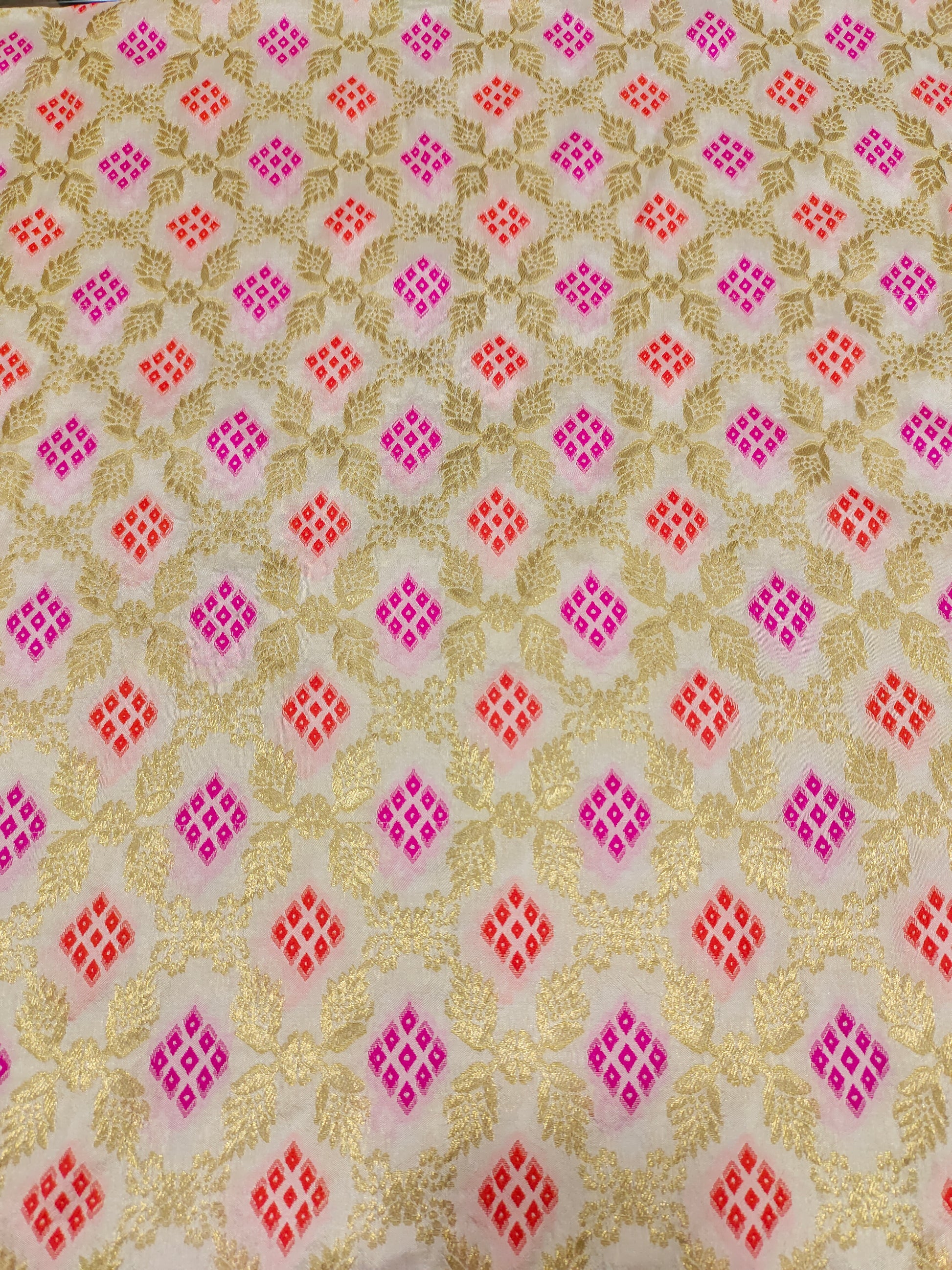 Banarasi silk fabric weave of pink and orange outline gold