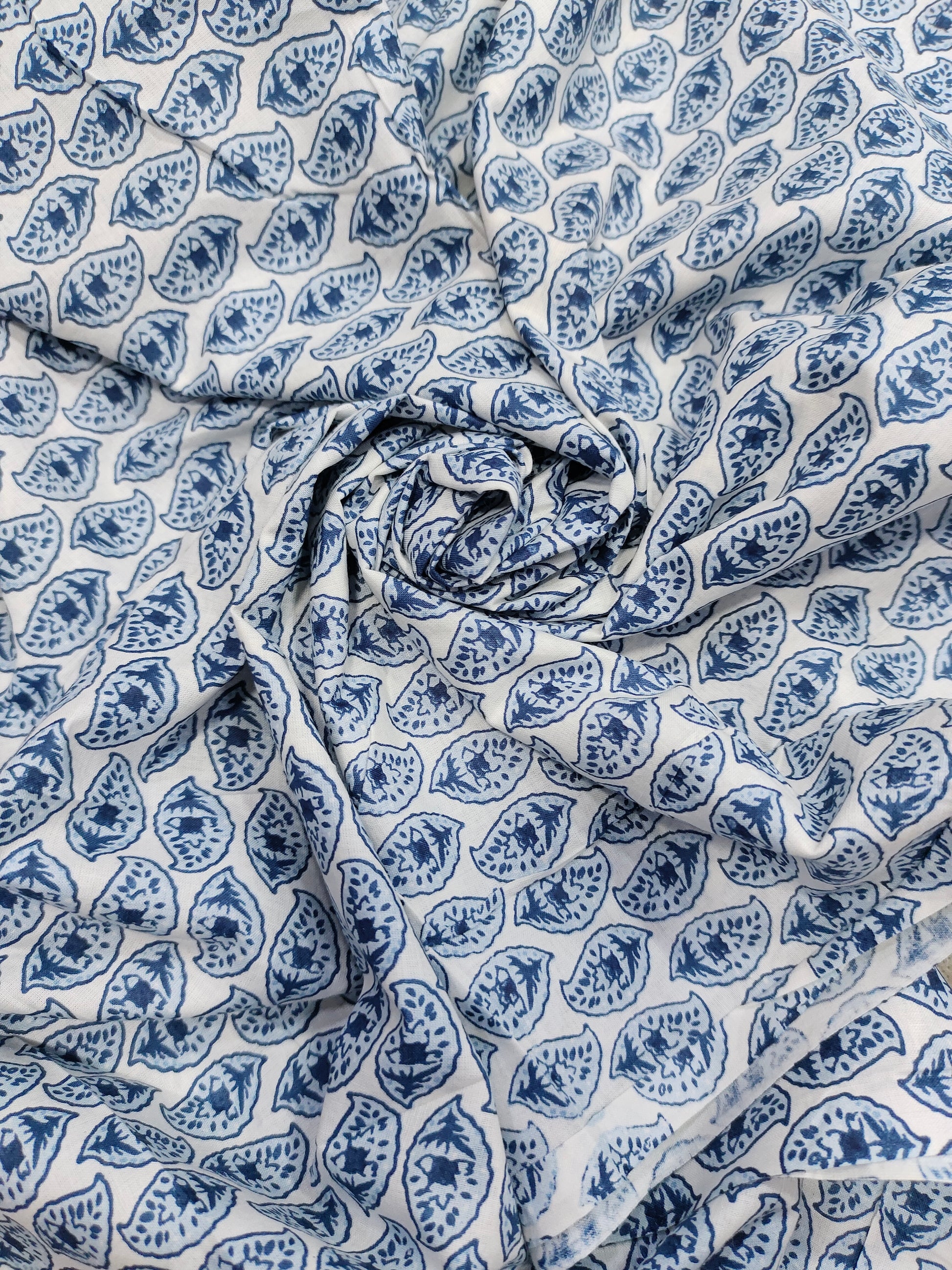 White color fabric with blue leaves print