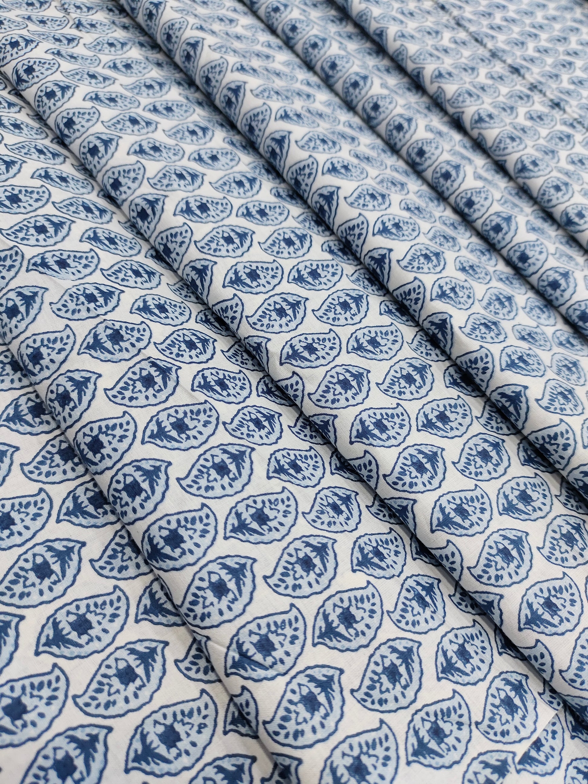 White color fabric with blue leaves print
