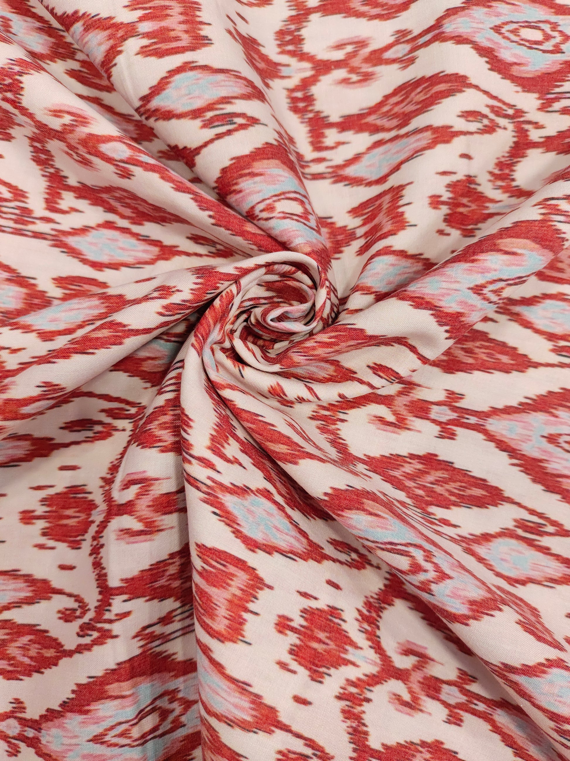 Cotton cream base with ikkat type red and grey print.