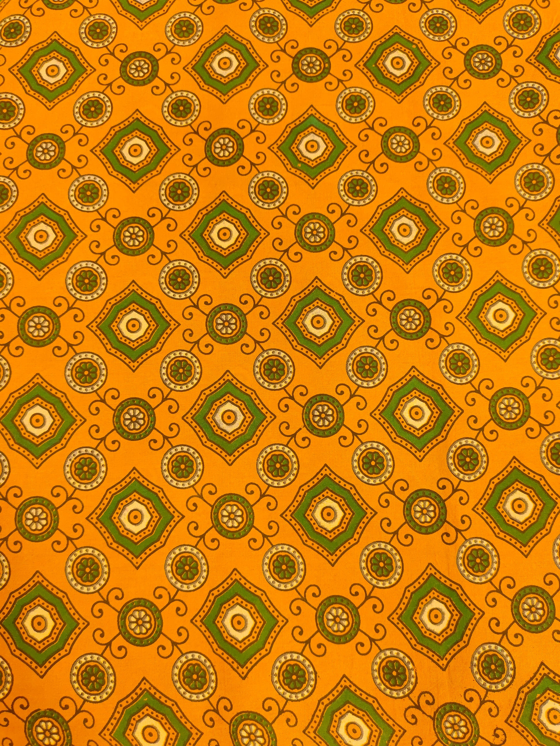 Dark yellow ajrak print with green squares and circles.
