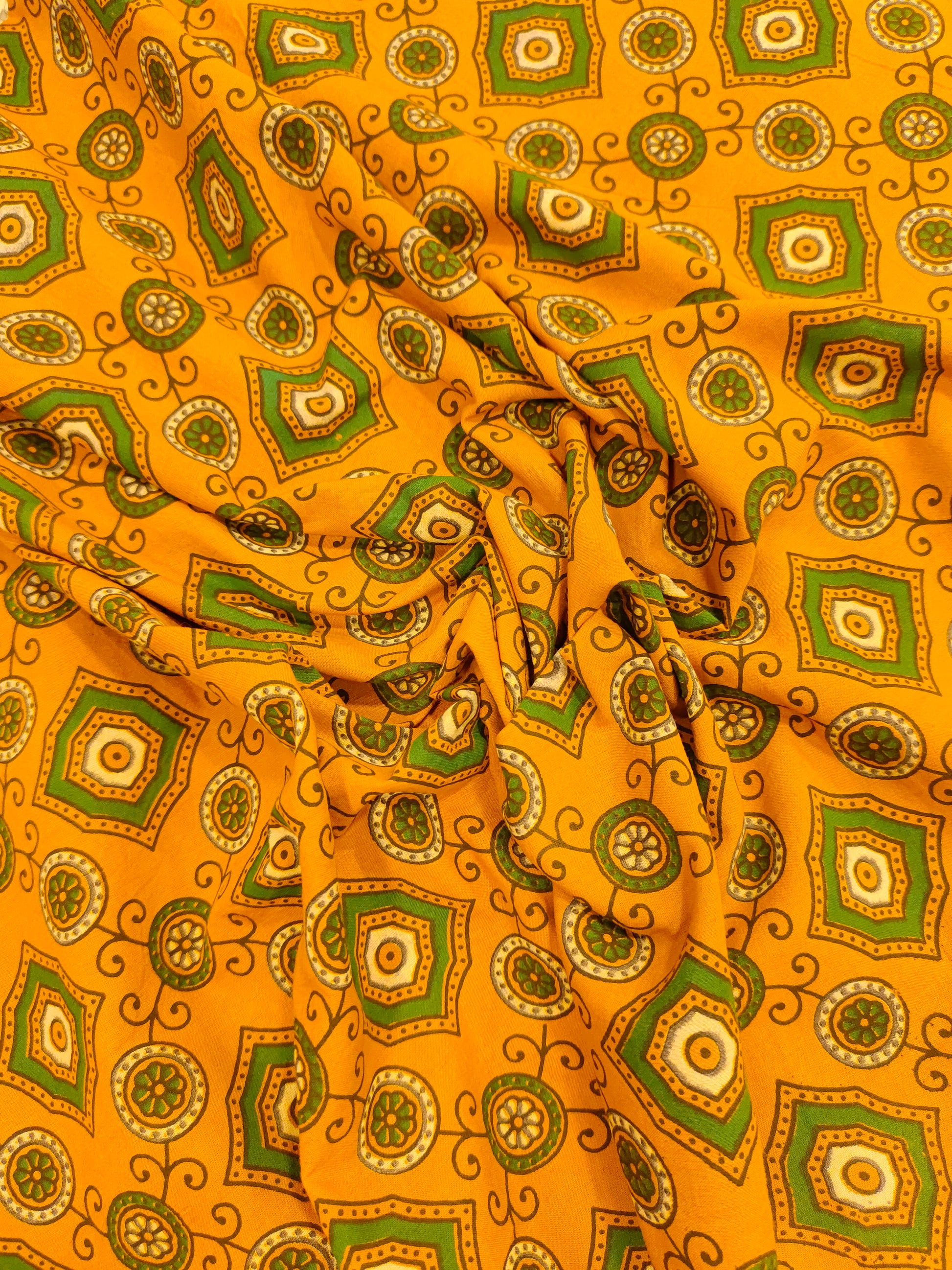 Dark yellow ajrak print with green squares and circles.