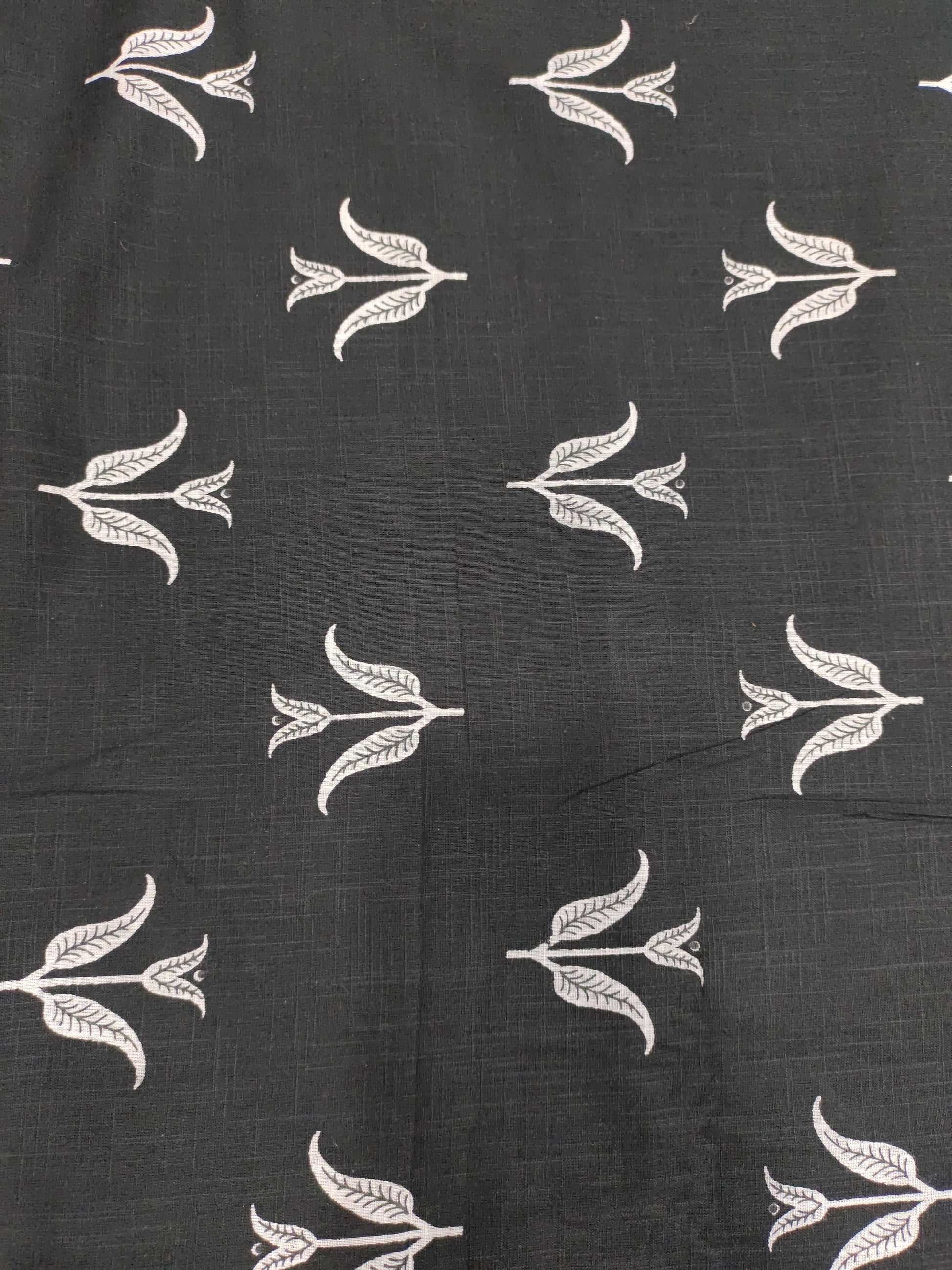 Black cotton slub fabric with leaves print.