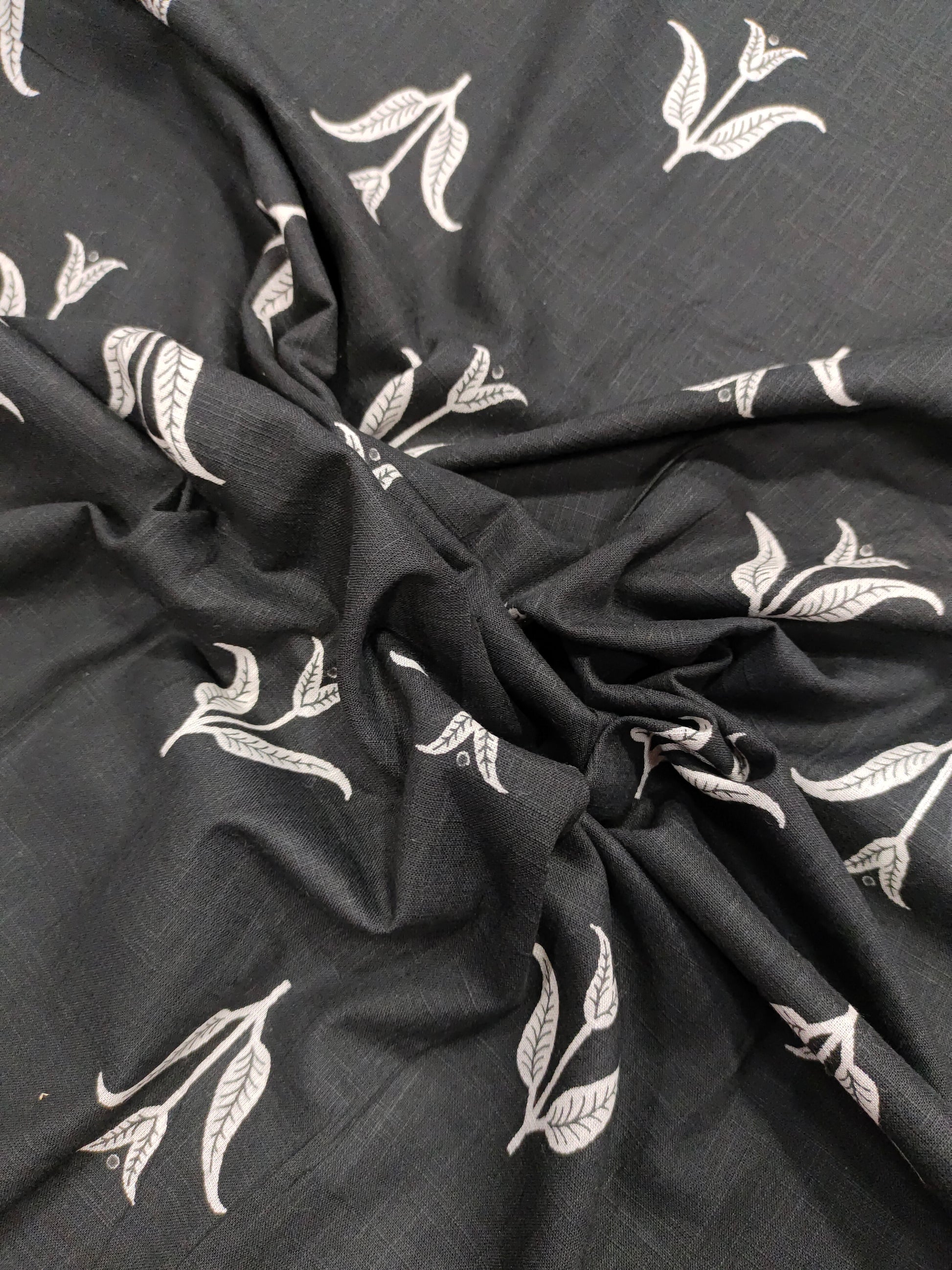 Black cotton slub fabric with leaves print.