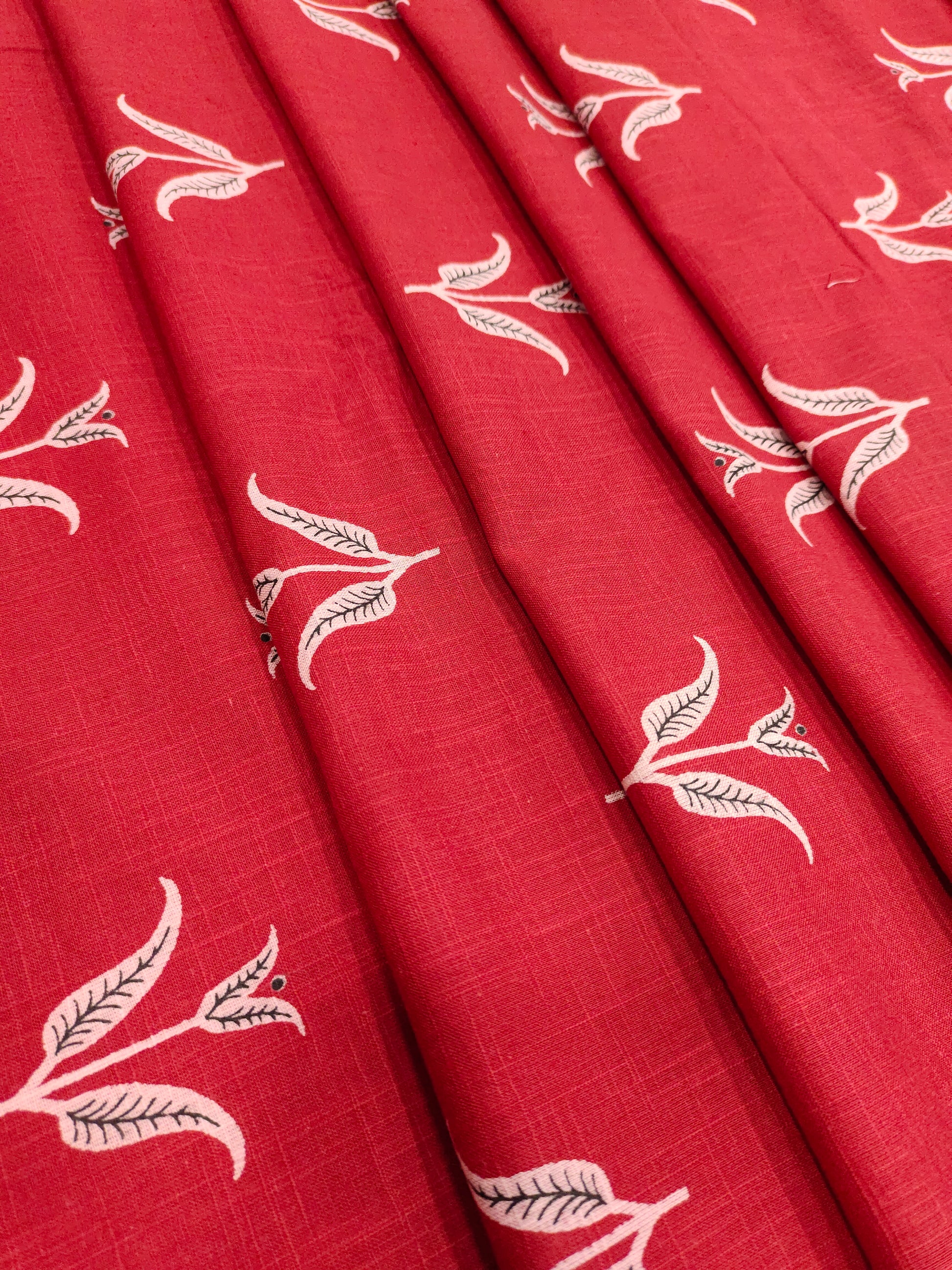 Red cotton slub fabric with black butti print.