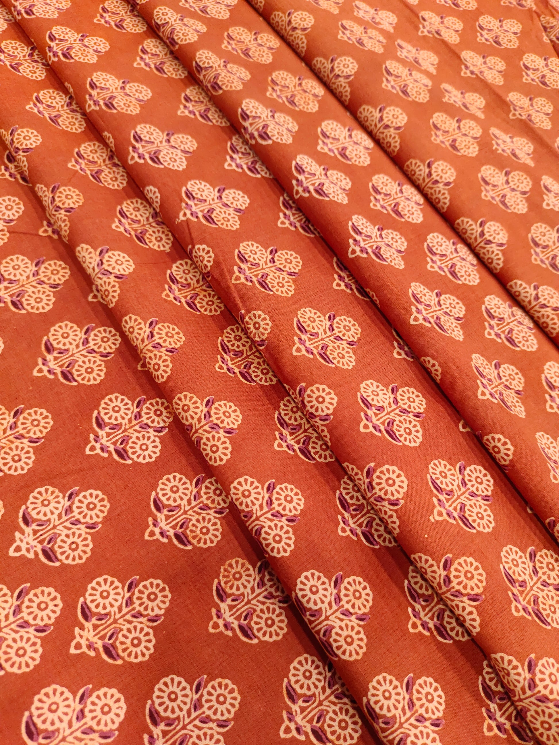 Orangish rust ajrak print with beige and maroon.