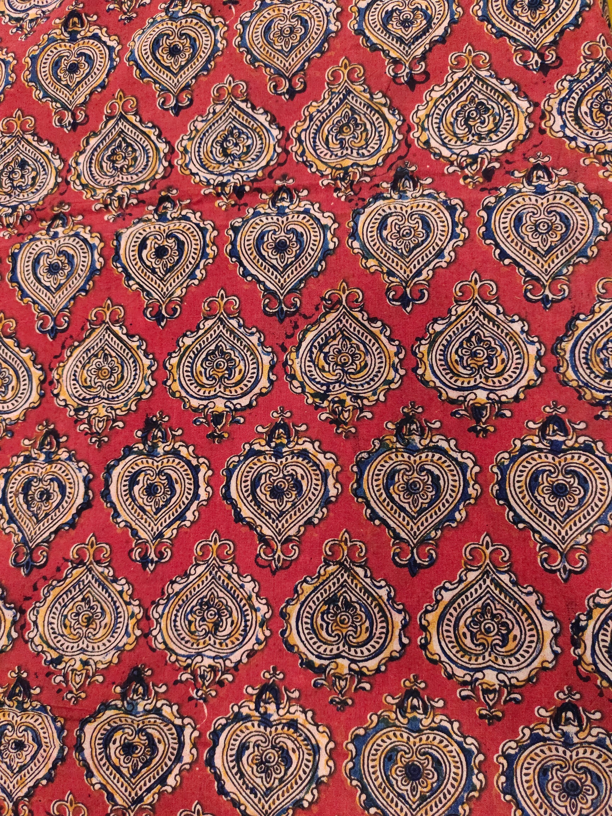 Maroon kalamkari print with yellow black and blue.