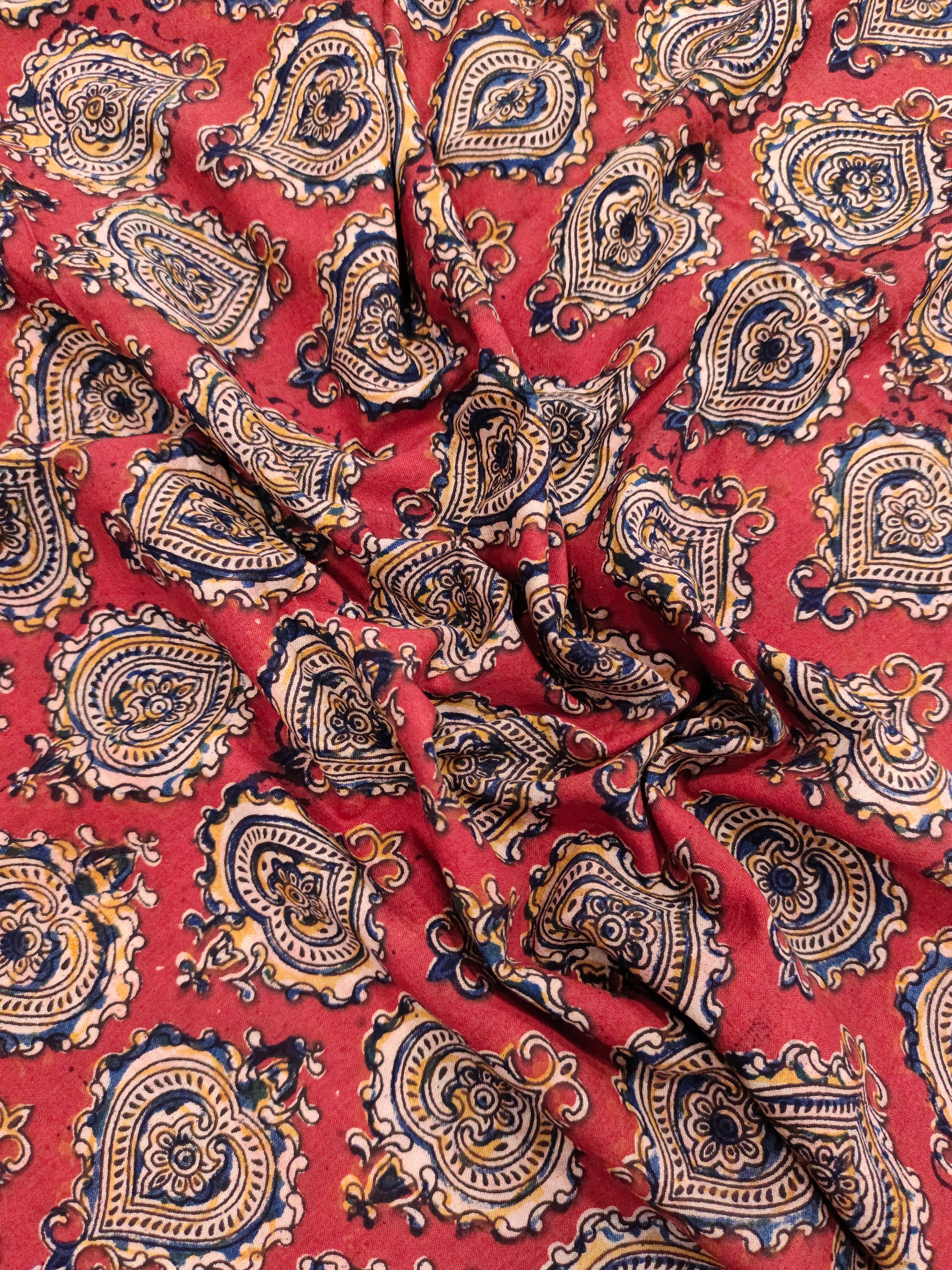 Maroon kalamkari print with yellow black and blue.