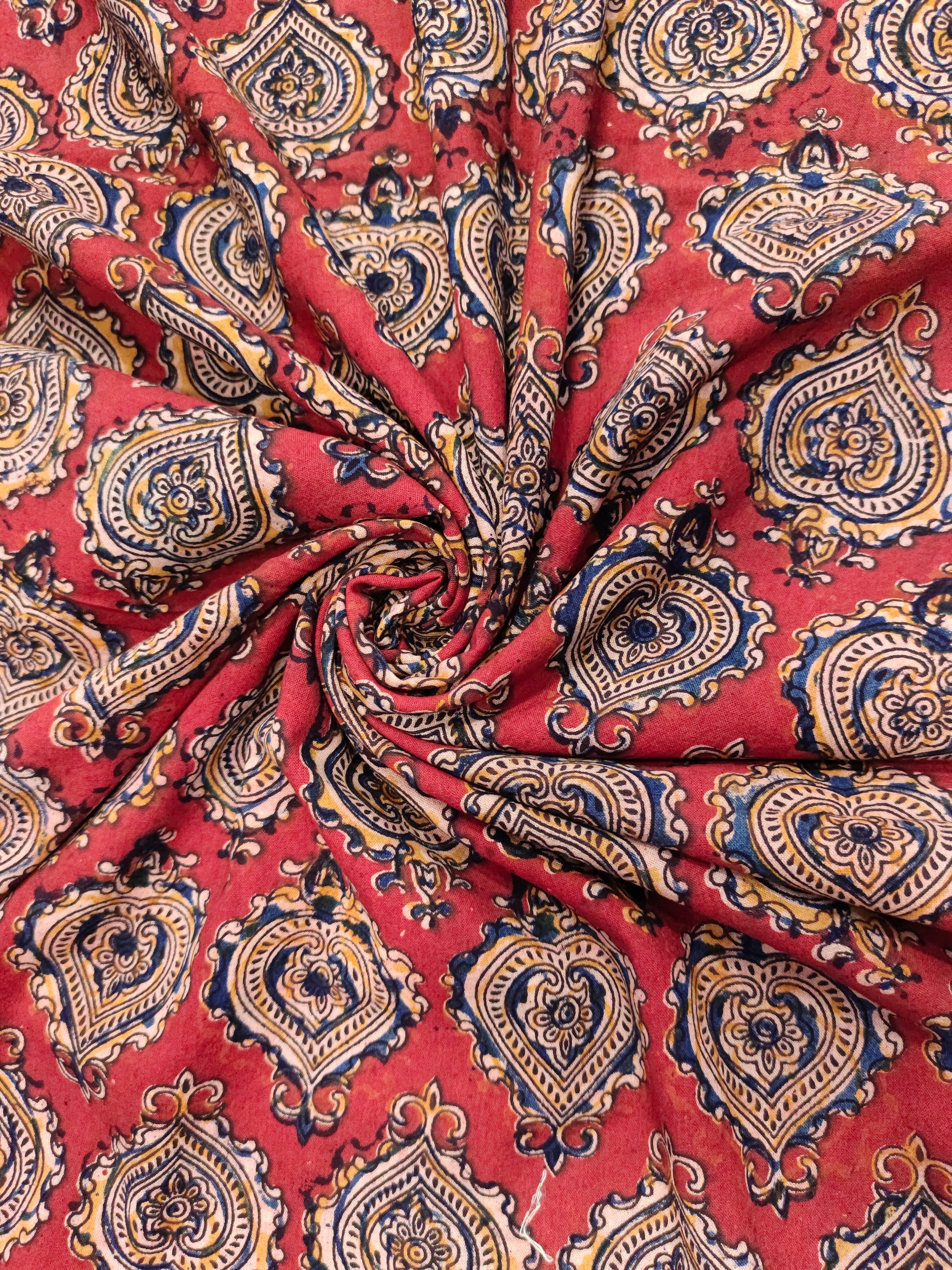 Maroon kalamkari print with yellow black and blue.