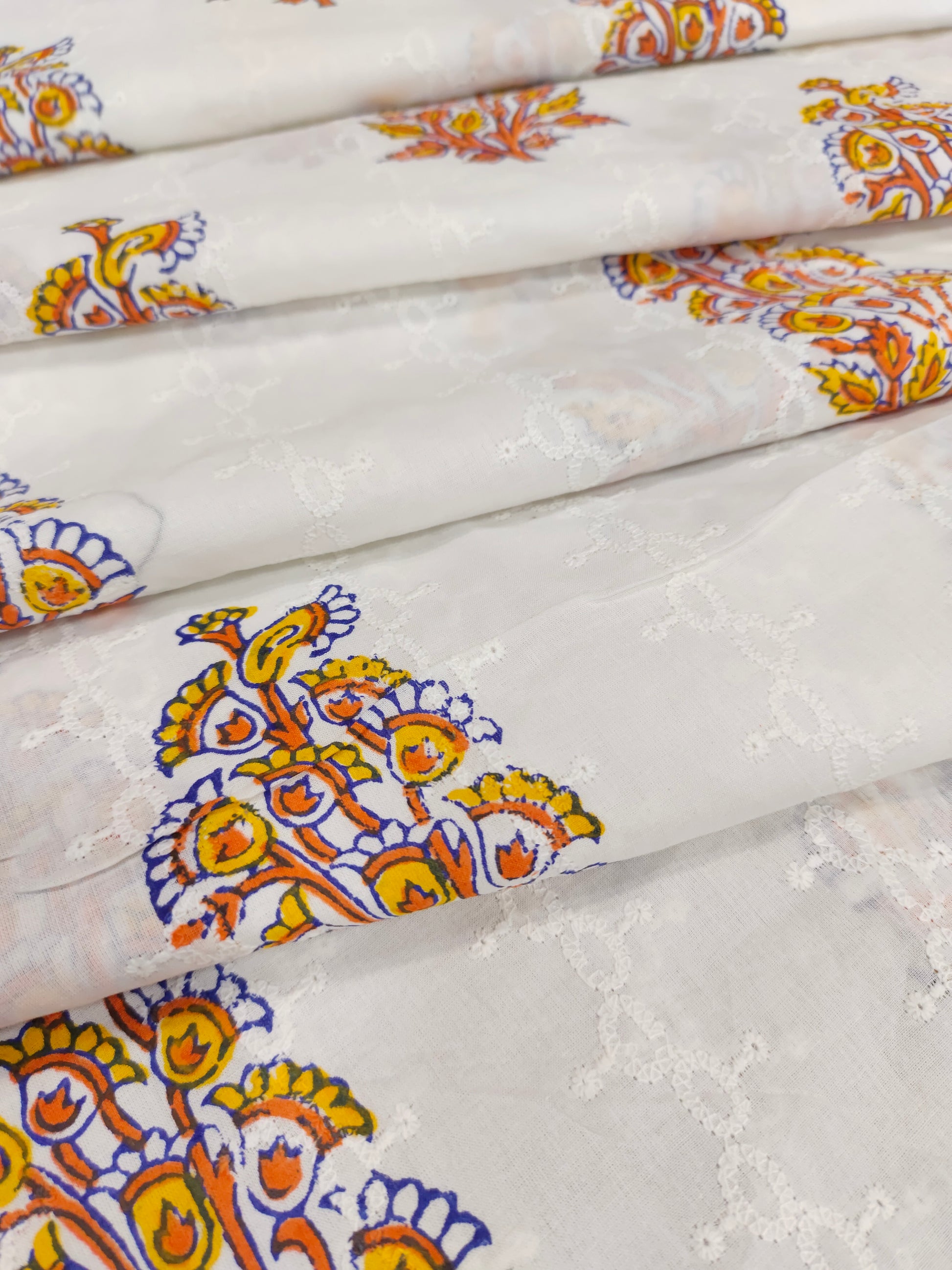 White embroidered fabric with orange handblock print
