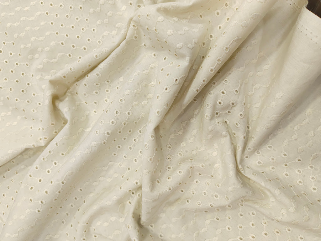 Off white embroidered fabric with small holes
