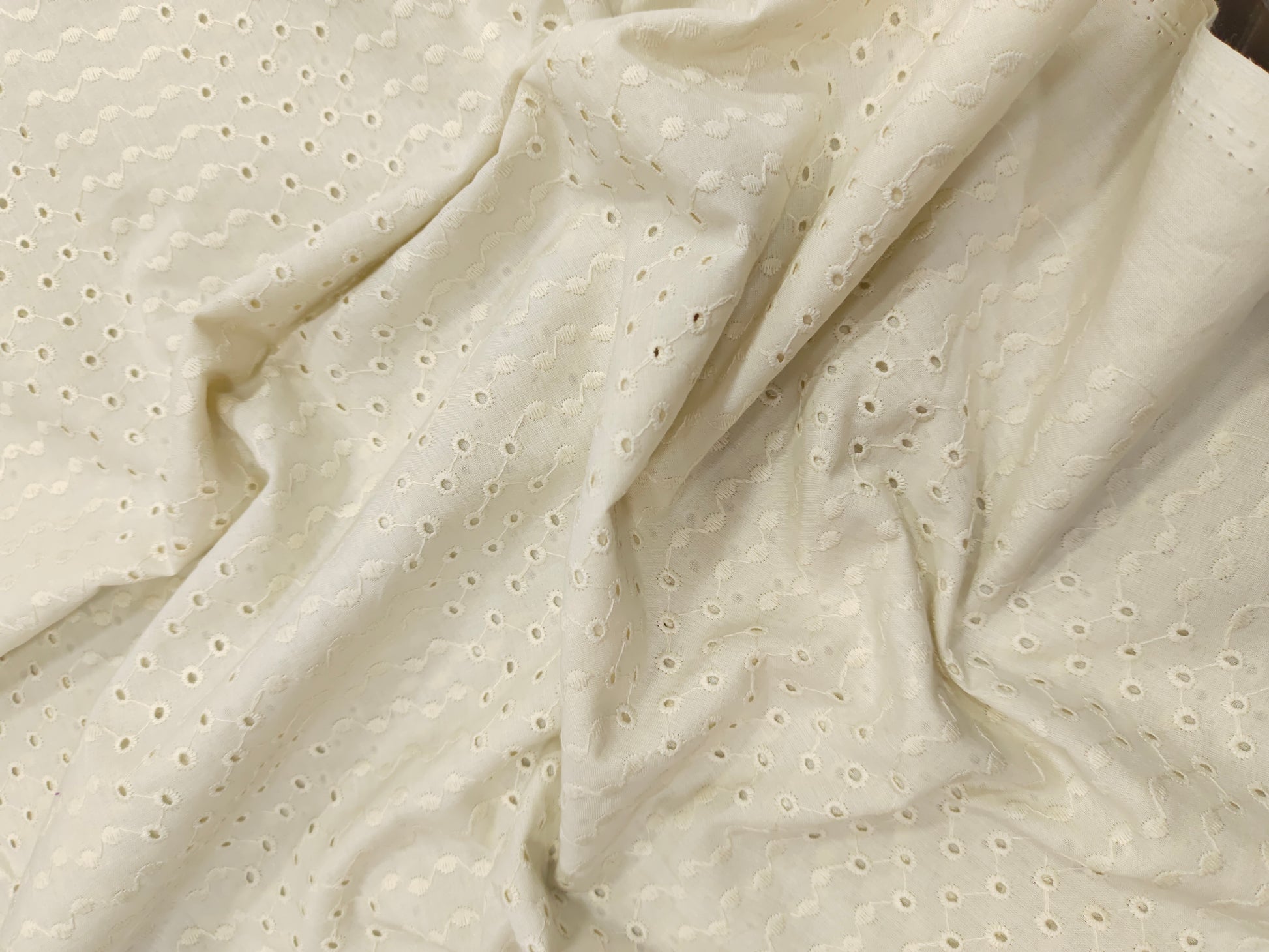 Off white embroidered fabric with small holes