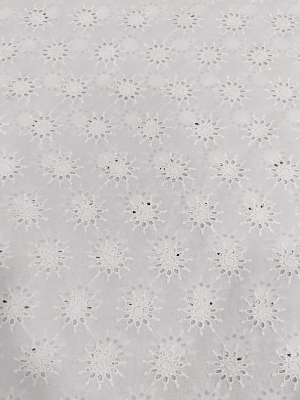 White embroidered cutwork fabric