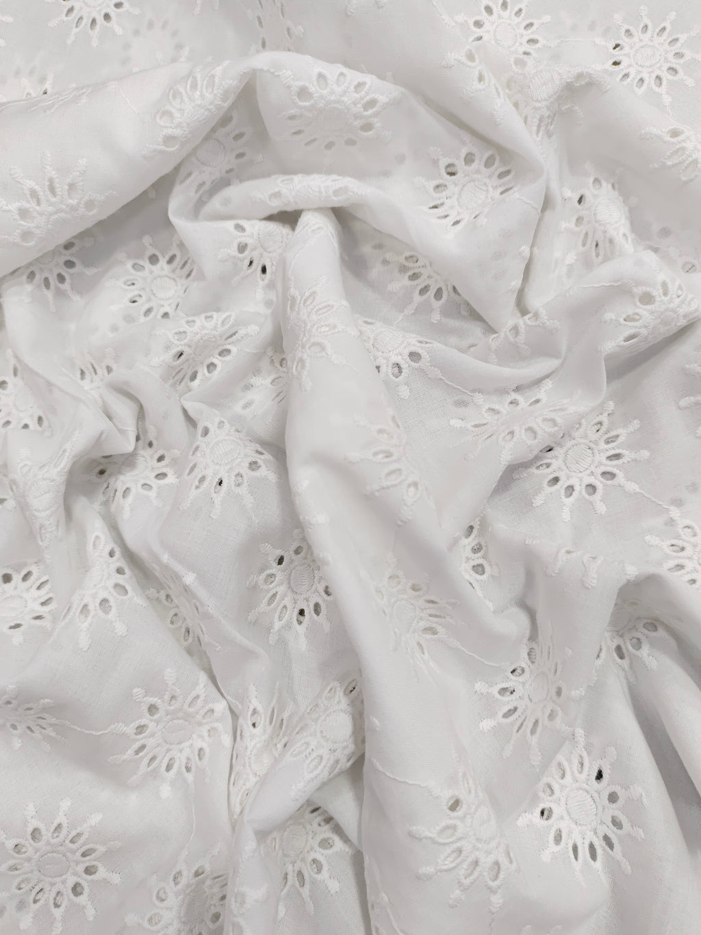 White embroidered cutwork fabric