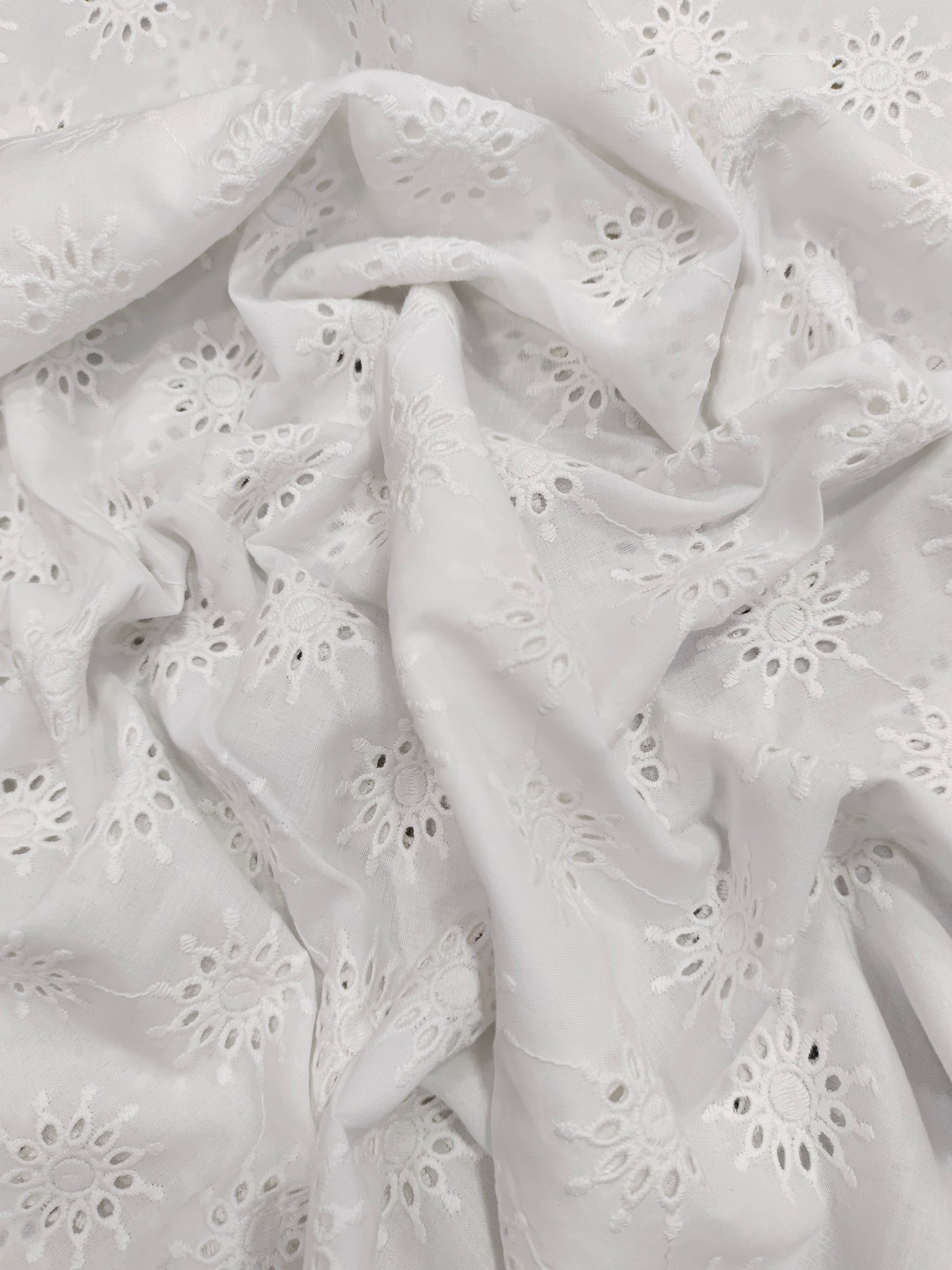 White embroidered cutwork fabric