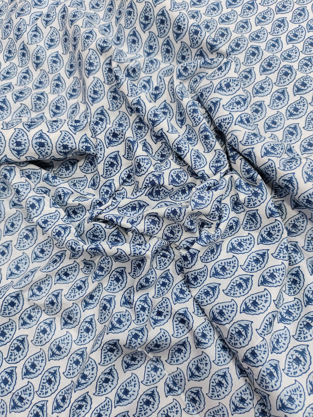 White color fabric with blue leaves print