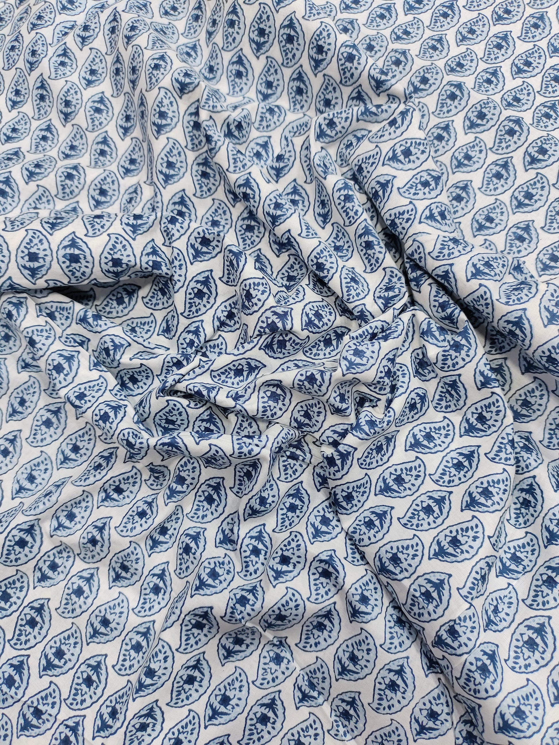 White color fabric with blue leaves print