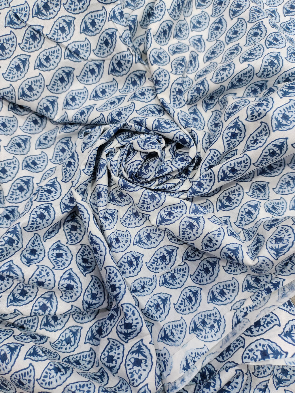 White color fabric with blue leaves print