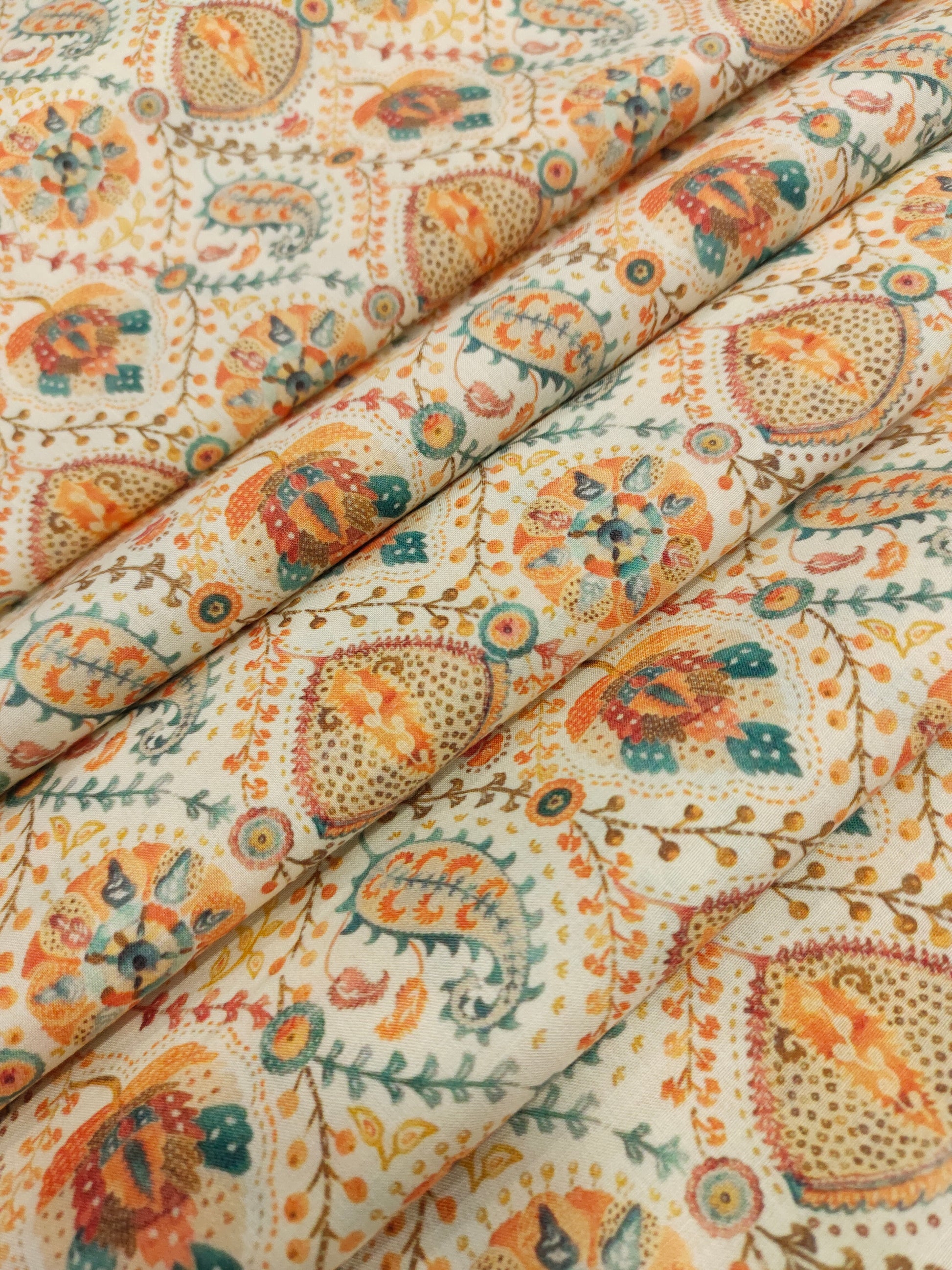 Cotton digital print with orange and blue on cream base.