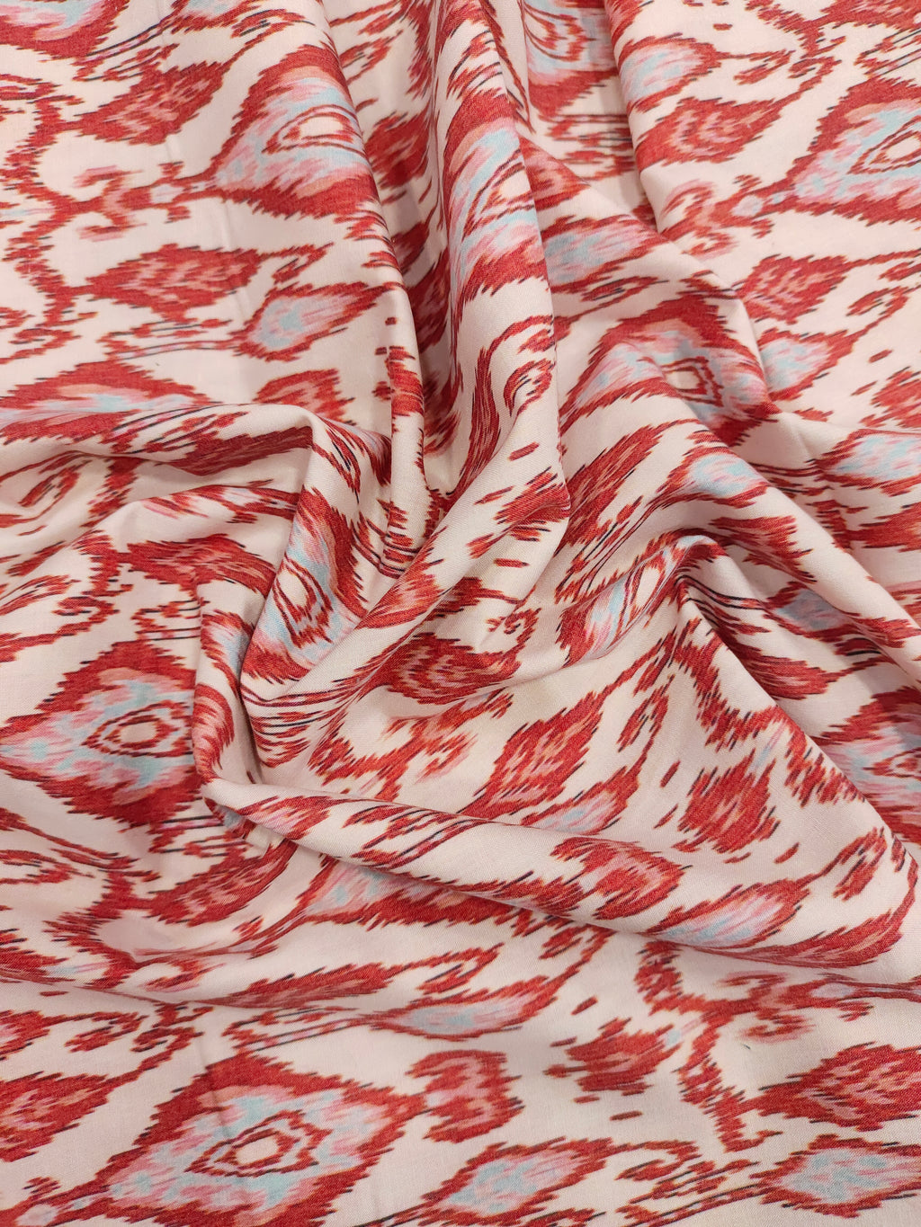 Cotton cream base with ikkat type red and grey print.