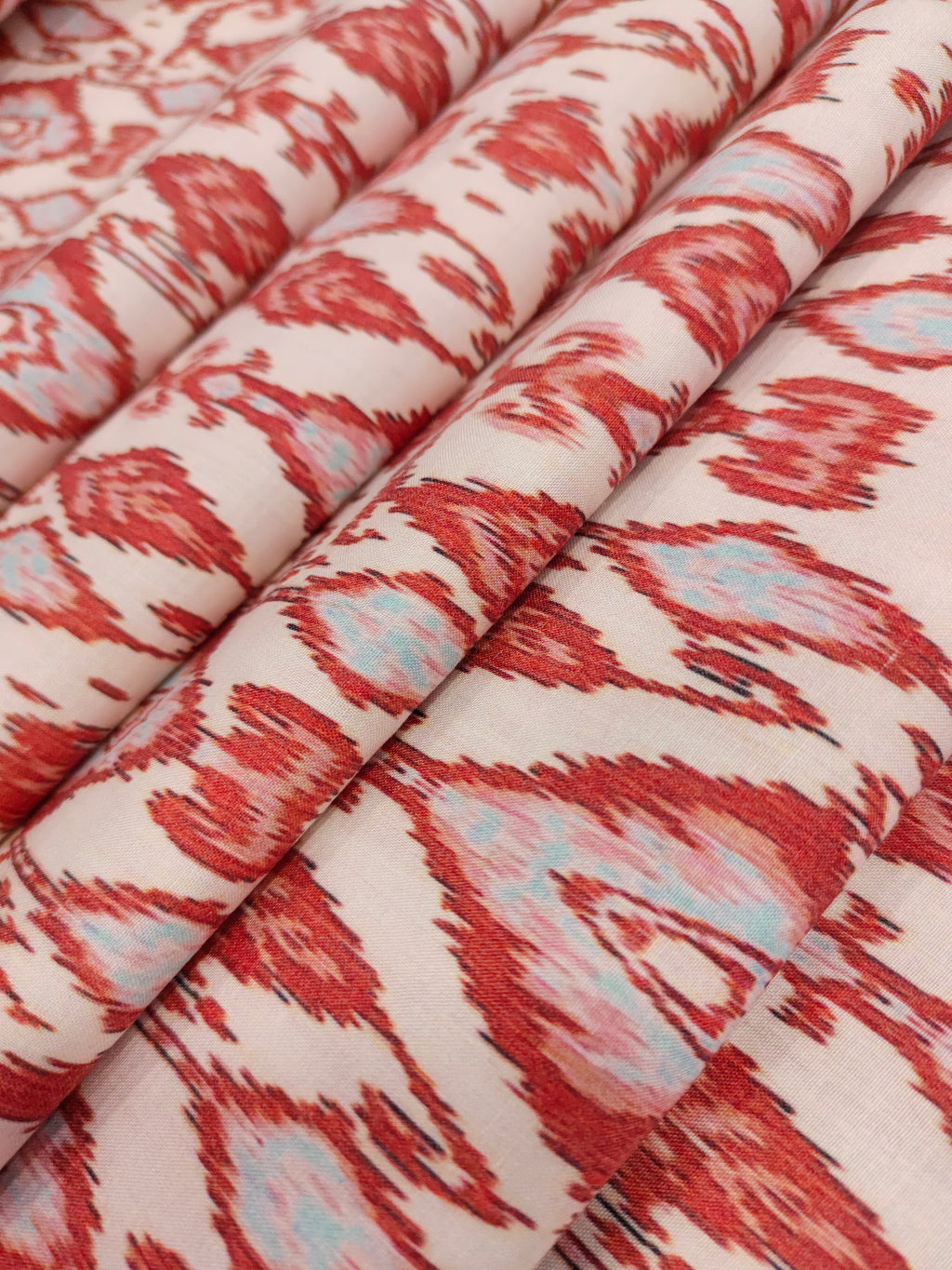 Cotton cream base with ikkat type red and grey print.