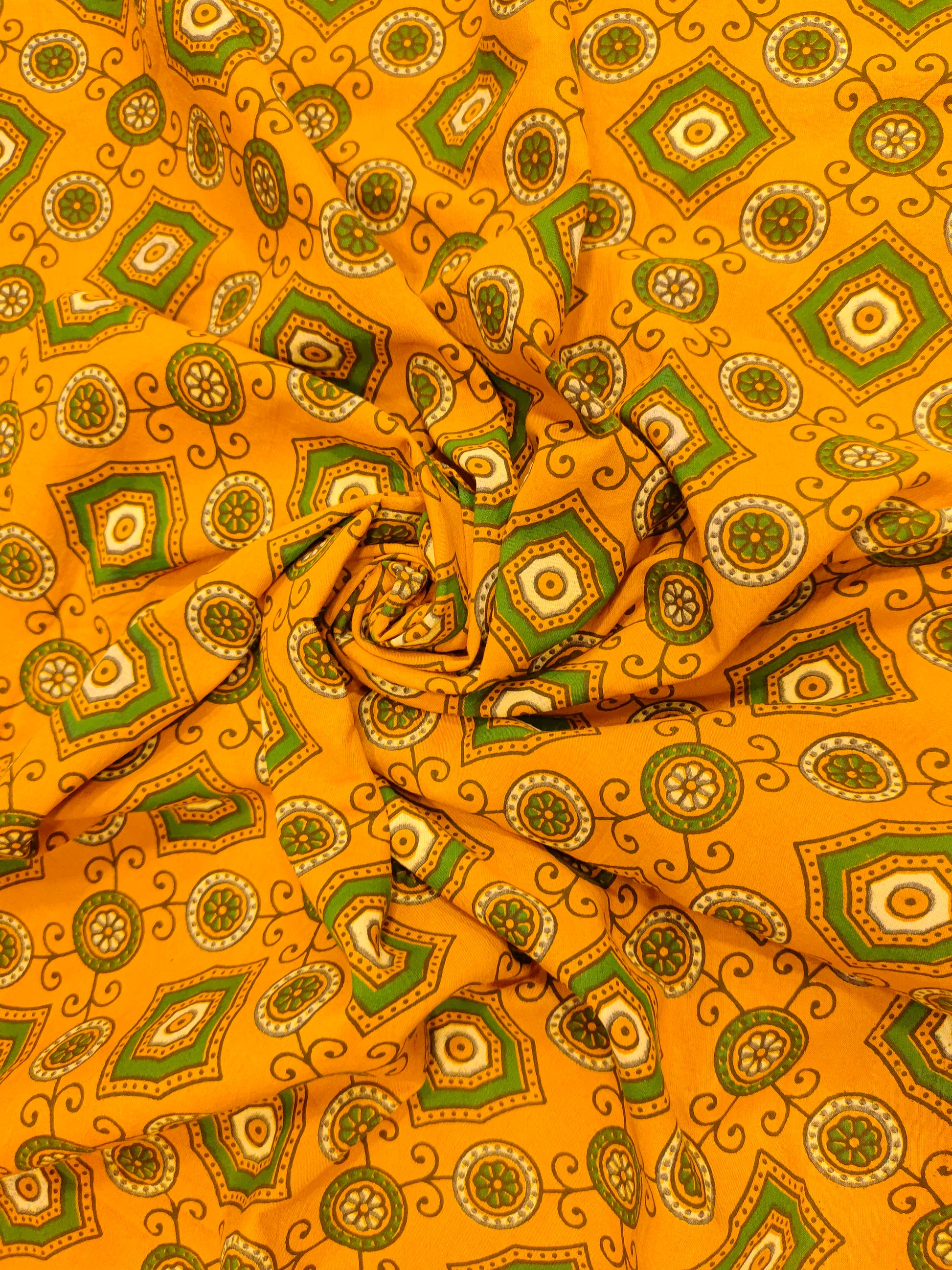 Dark yellow ajrak print with green squares and circles.