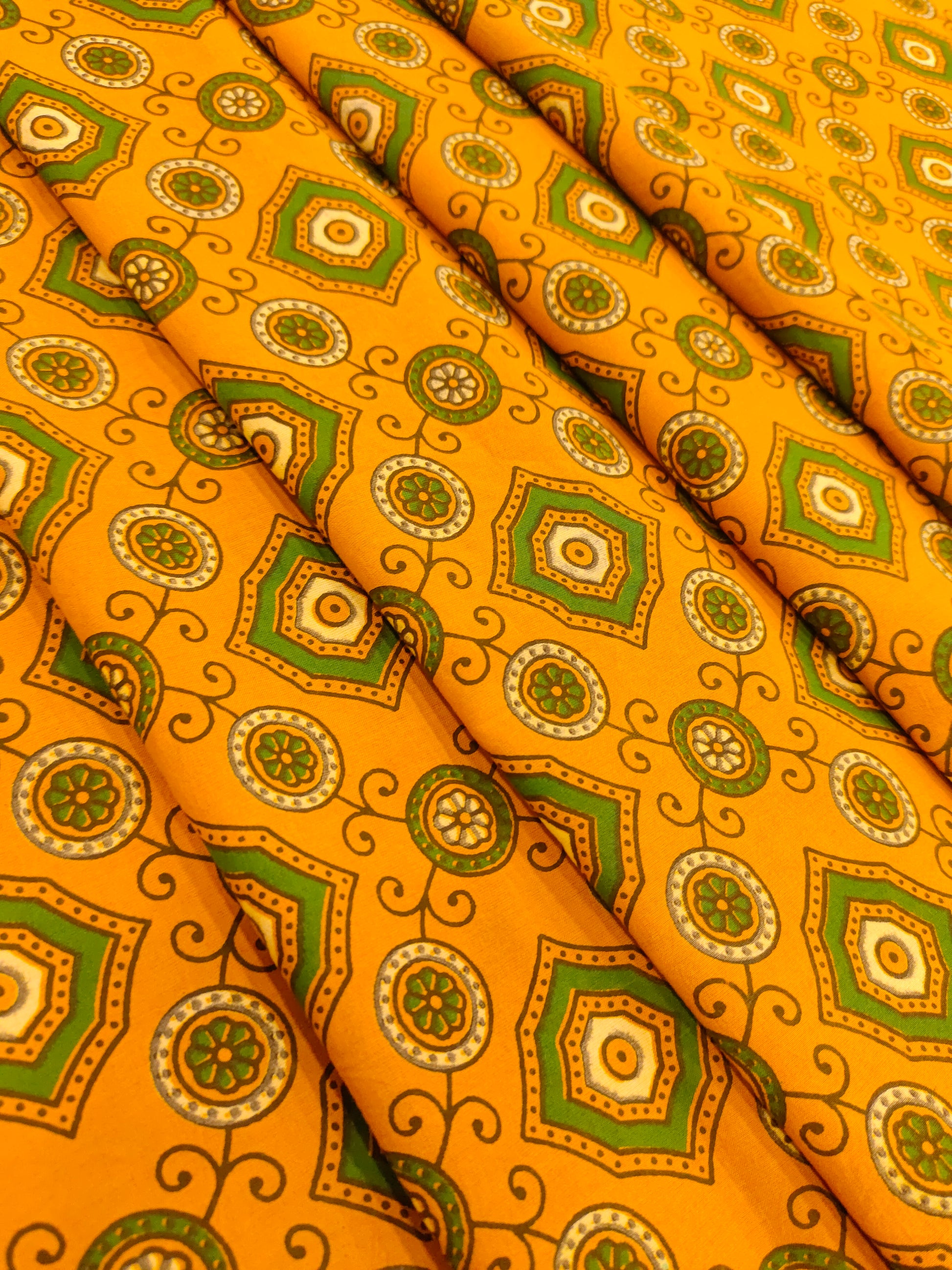 Dark yellow ajrak print with green squares and circles.