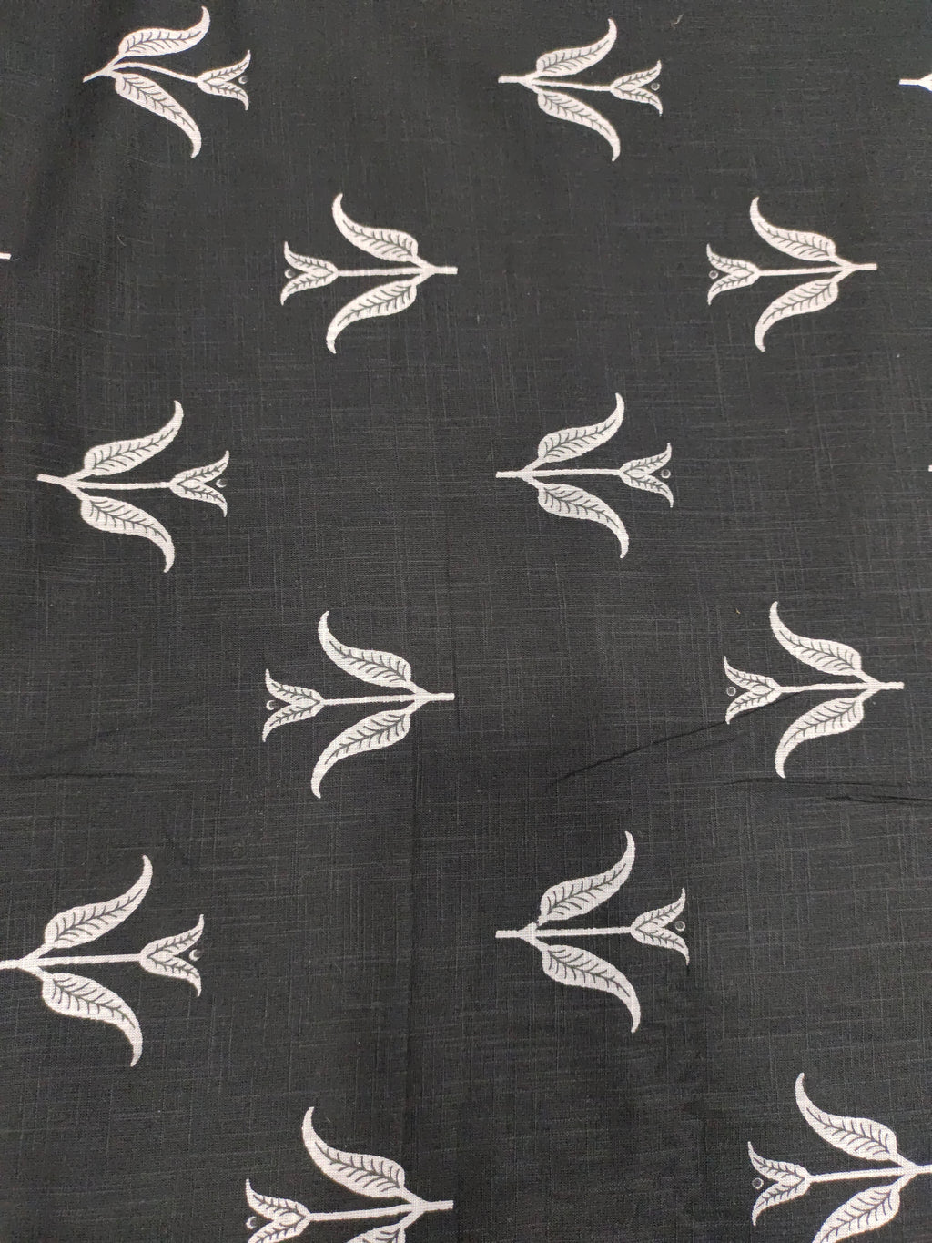 Black cotton slub fabric with leaves print.