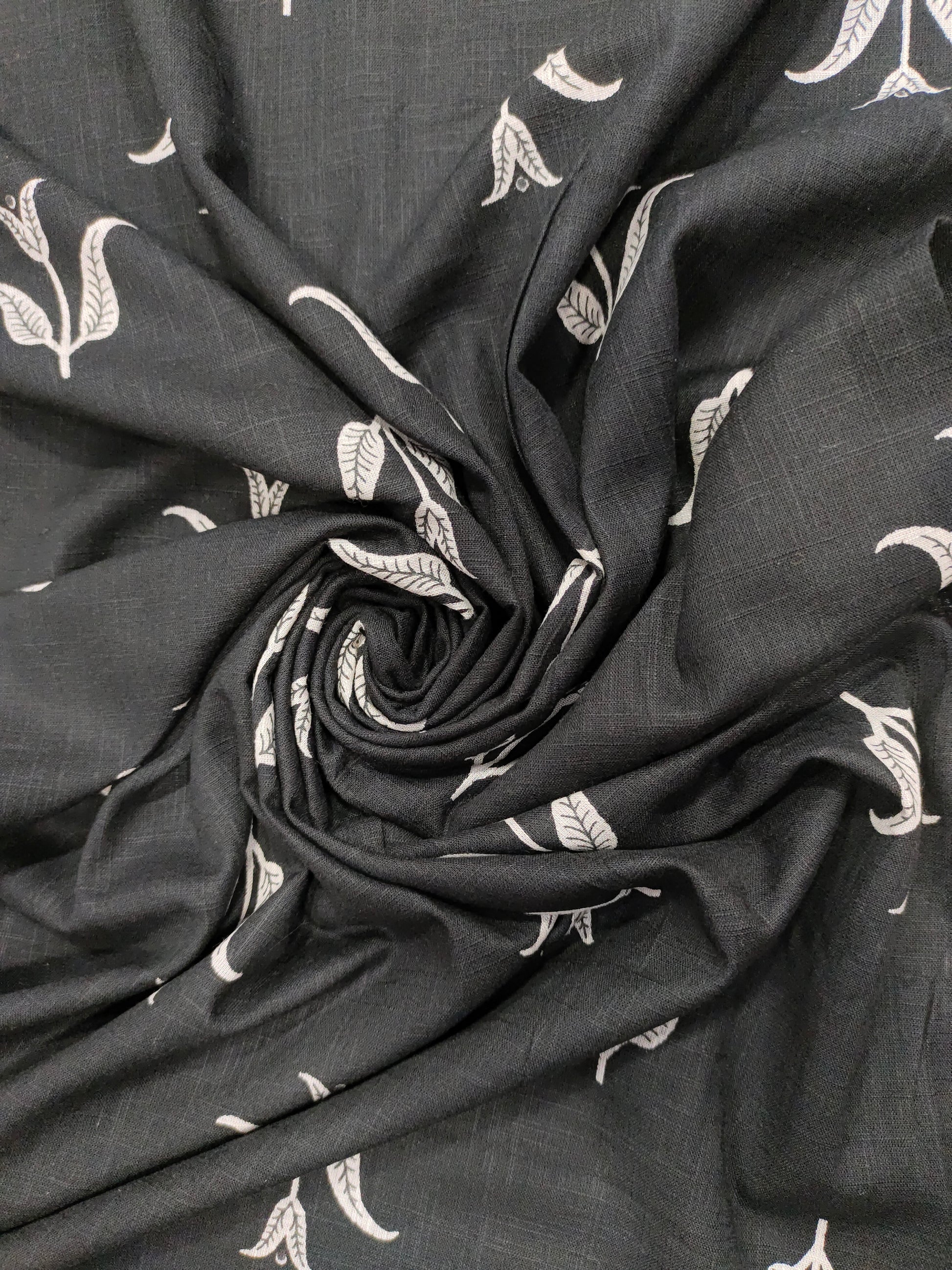 Black cotton slub fabric with leaves print.