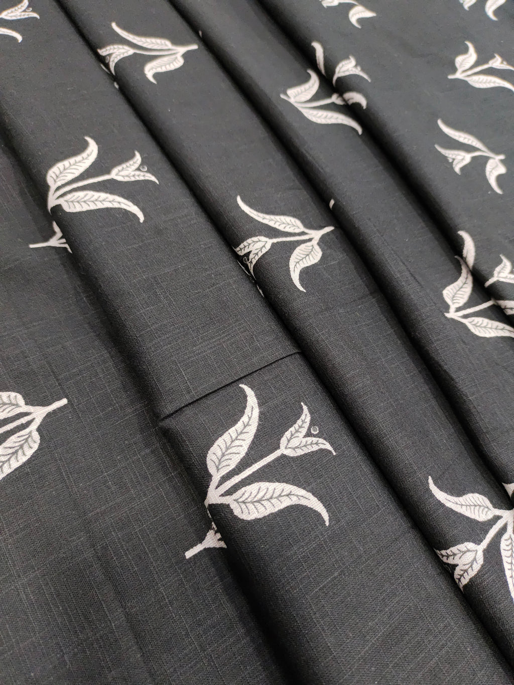 Black cotton slub fabric with leaves print.