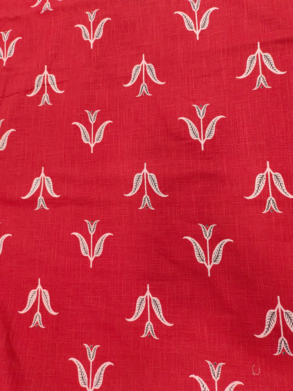 Red cotton slub fabric with black butti print.