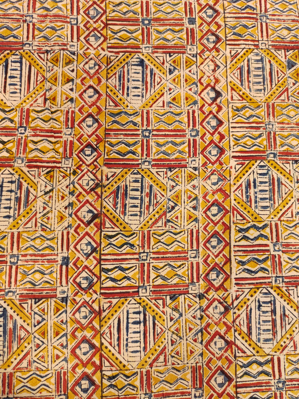 Dark mustard kalamkari printed with red and blue.