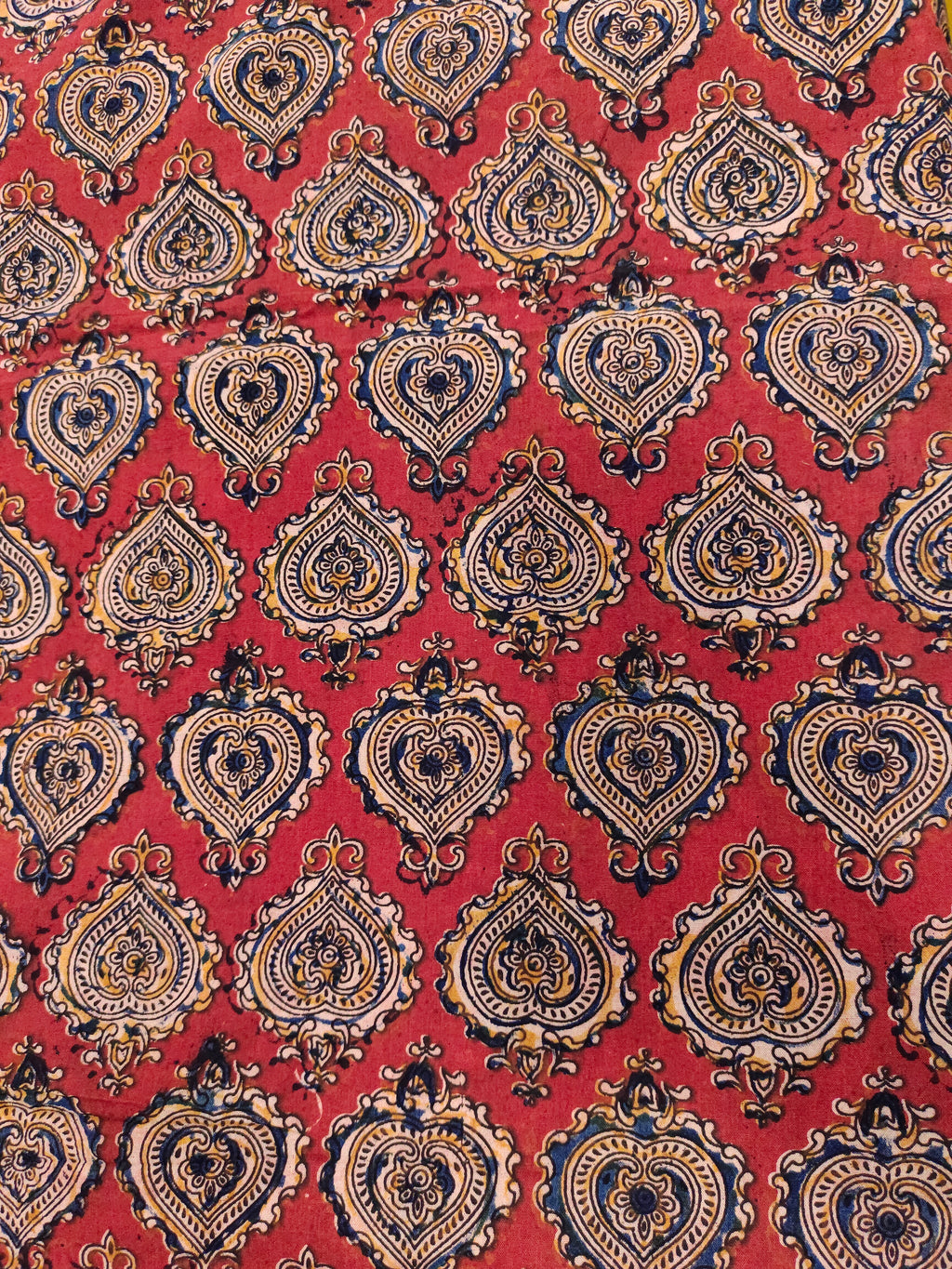 Maroon kalamkari print with yellow black and blue.