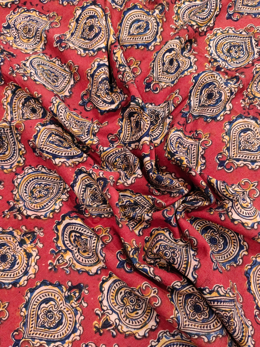 Maroon kalamkari print with yellow black and blue.