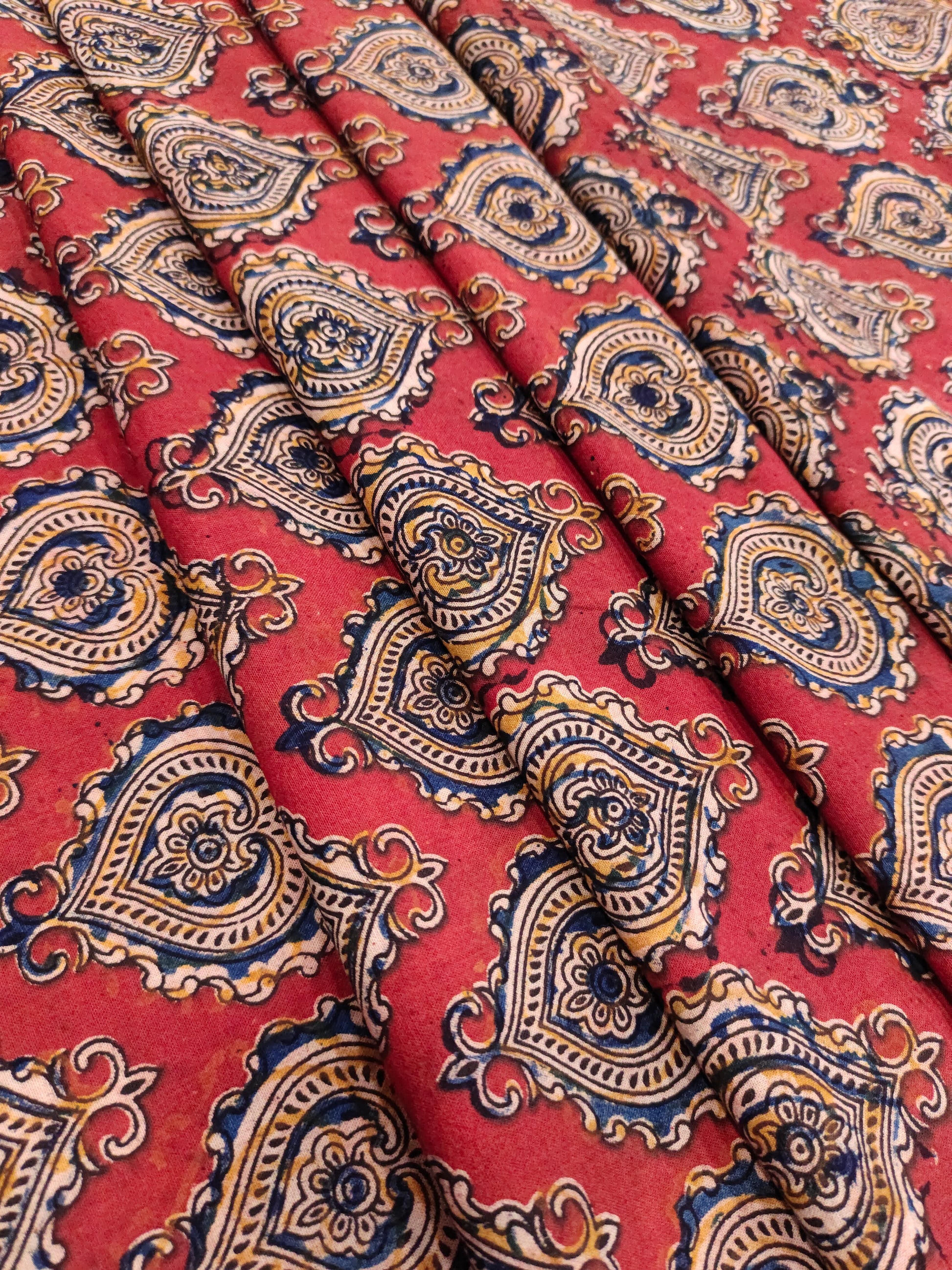 Maroon kalamkari print with yellow black and blue.