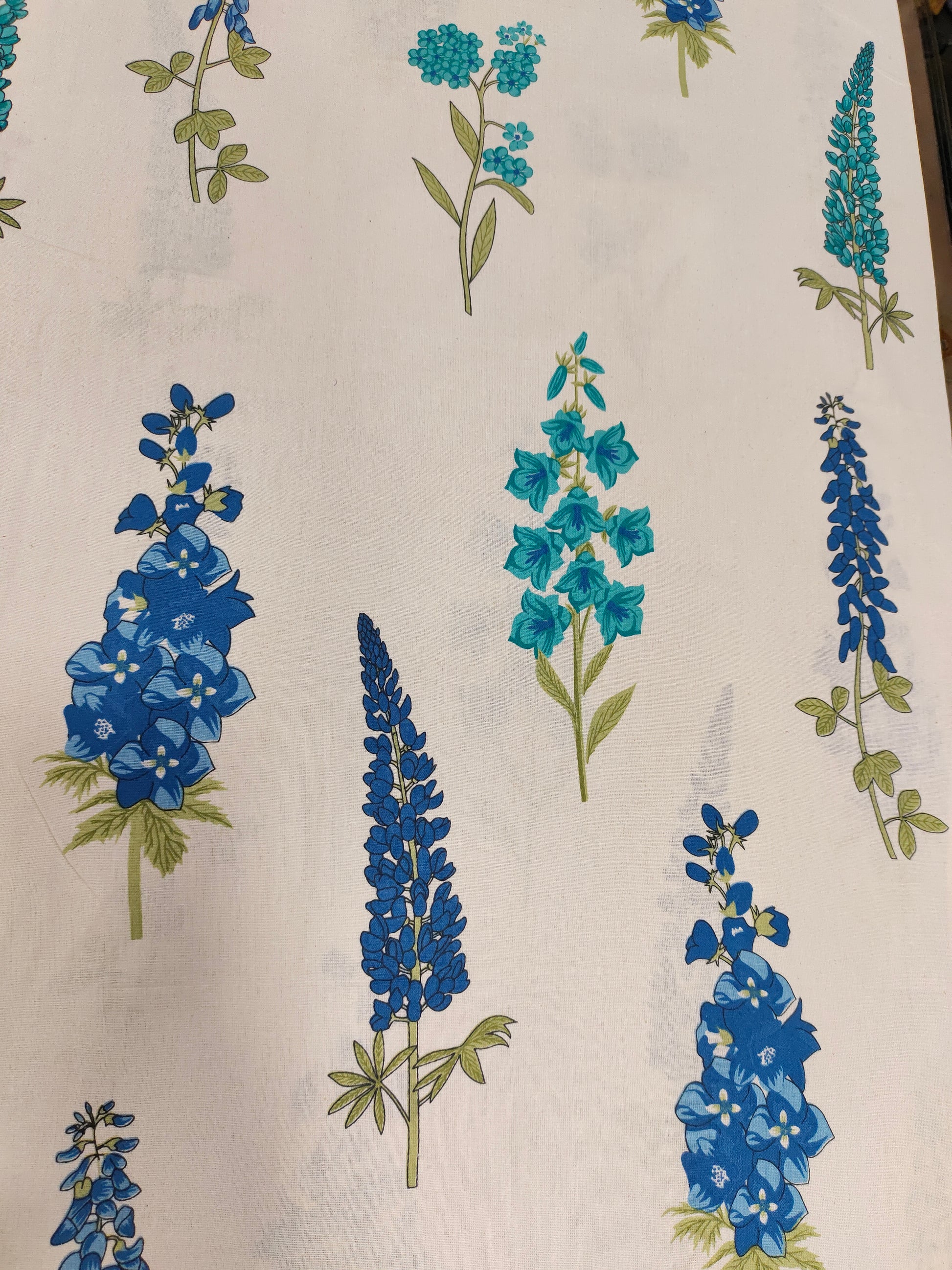 Cream cotton flex fabric stem type print with blue and green.