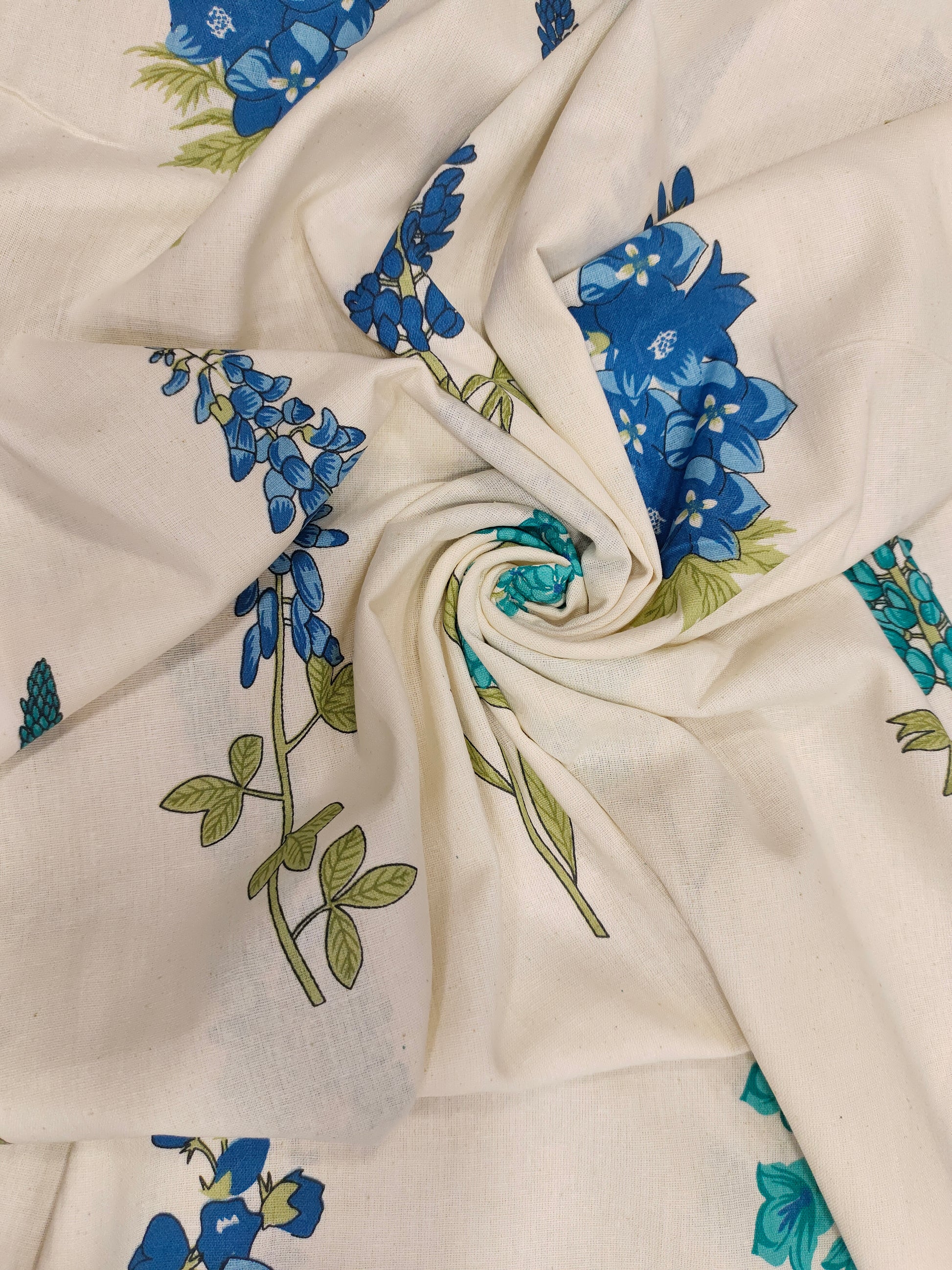 Cream cotton flex fabric stem type print with blue and green.