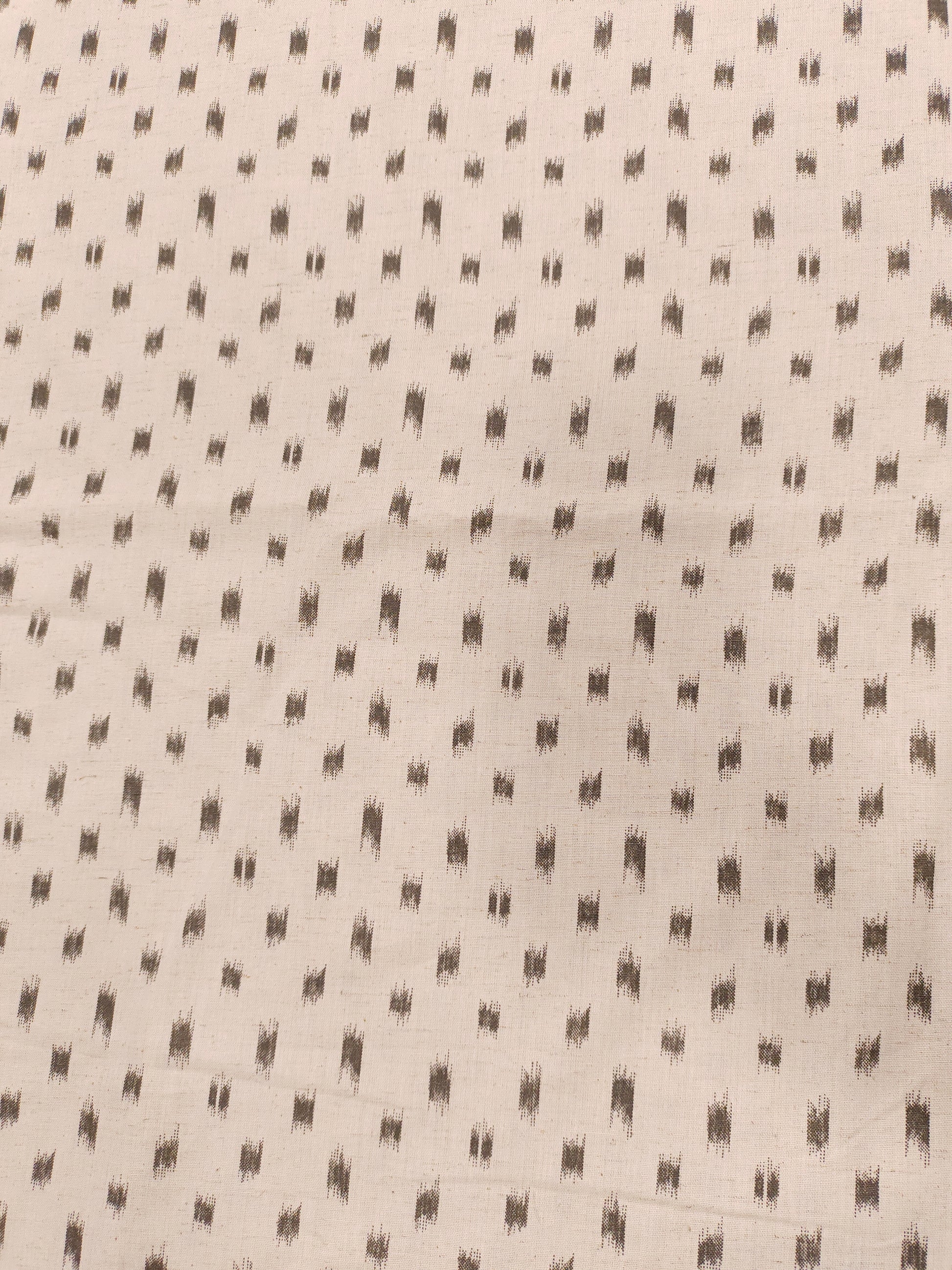 Flex cotton ikkat type print in grey color on cream fabric.