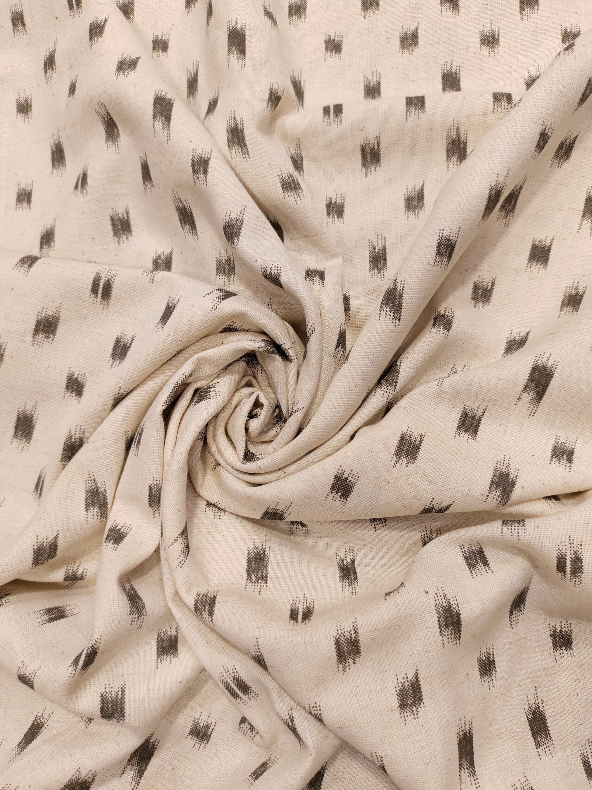 Flex cotton ikkat type print in grey color on cream fabric.