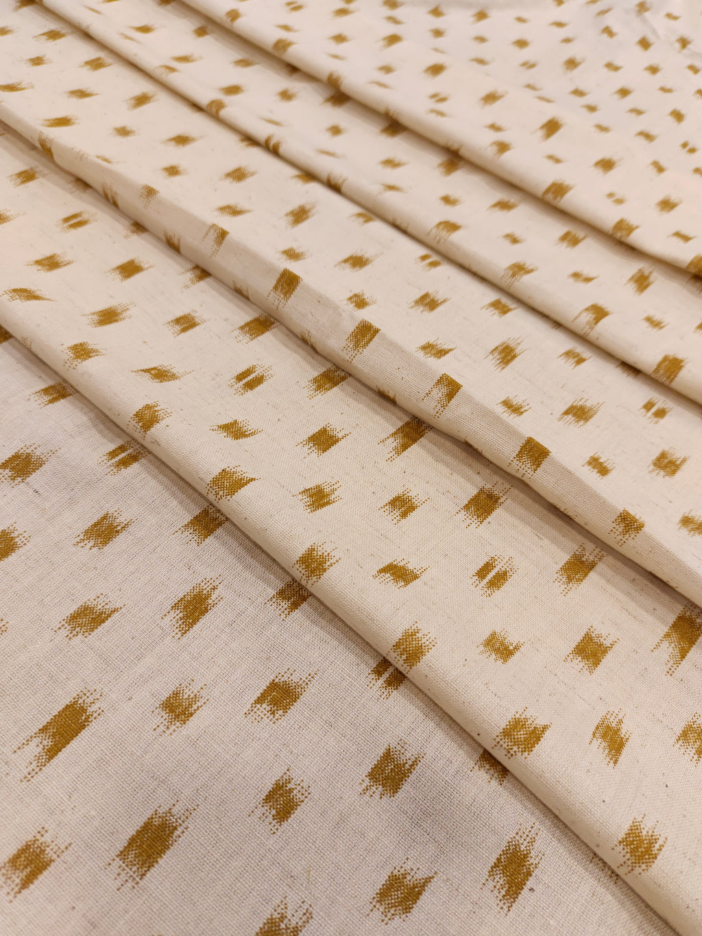 Cream cotton flex fabric mustard ikkat print.