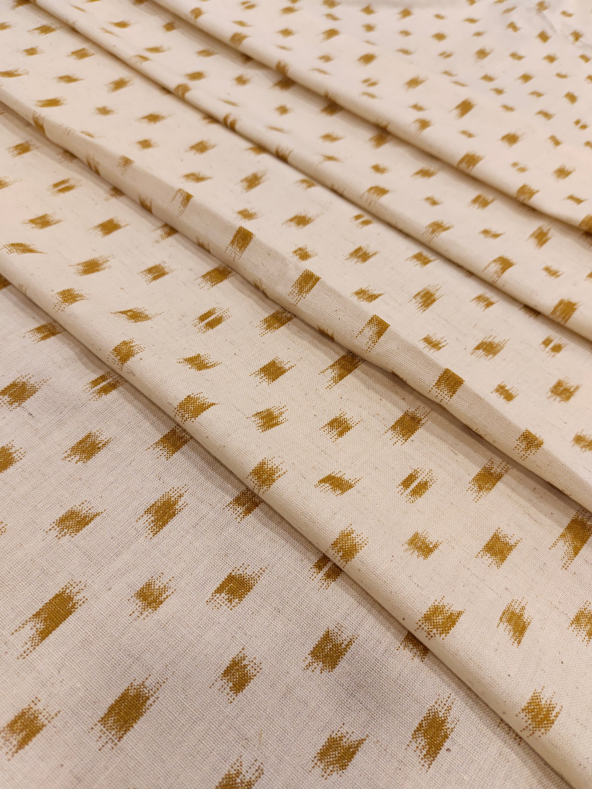 Cream cotton flex fabric mustard ikkat print.