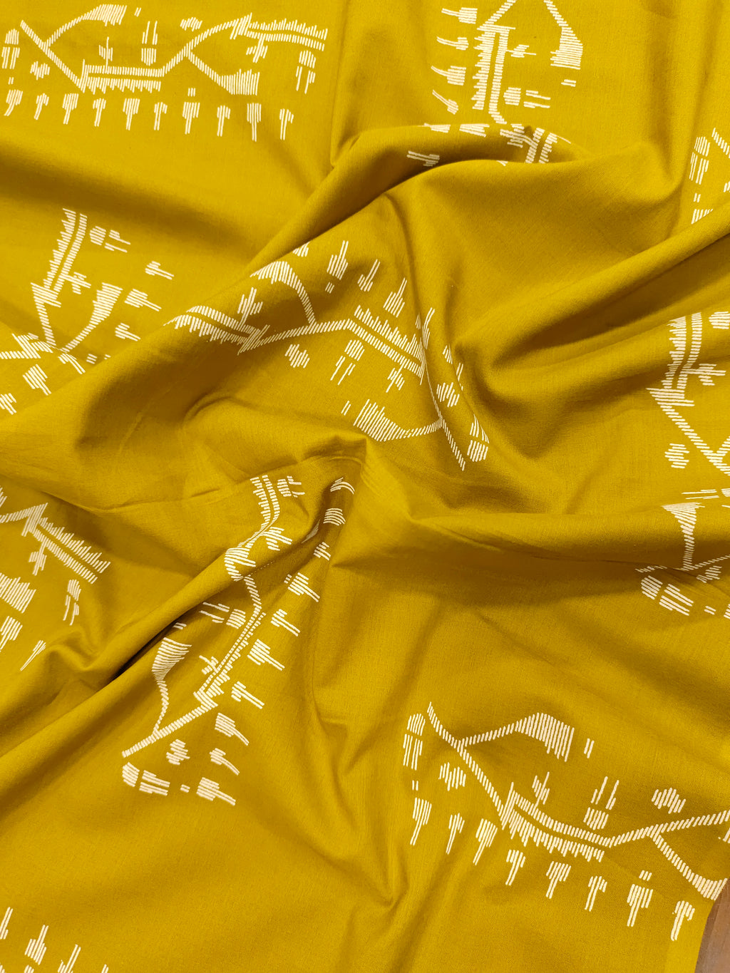 Mustard color cotton fabric with jamdani print in white.