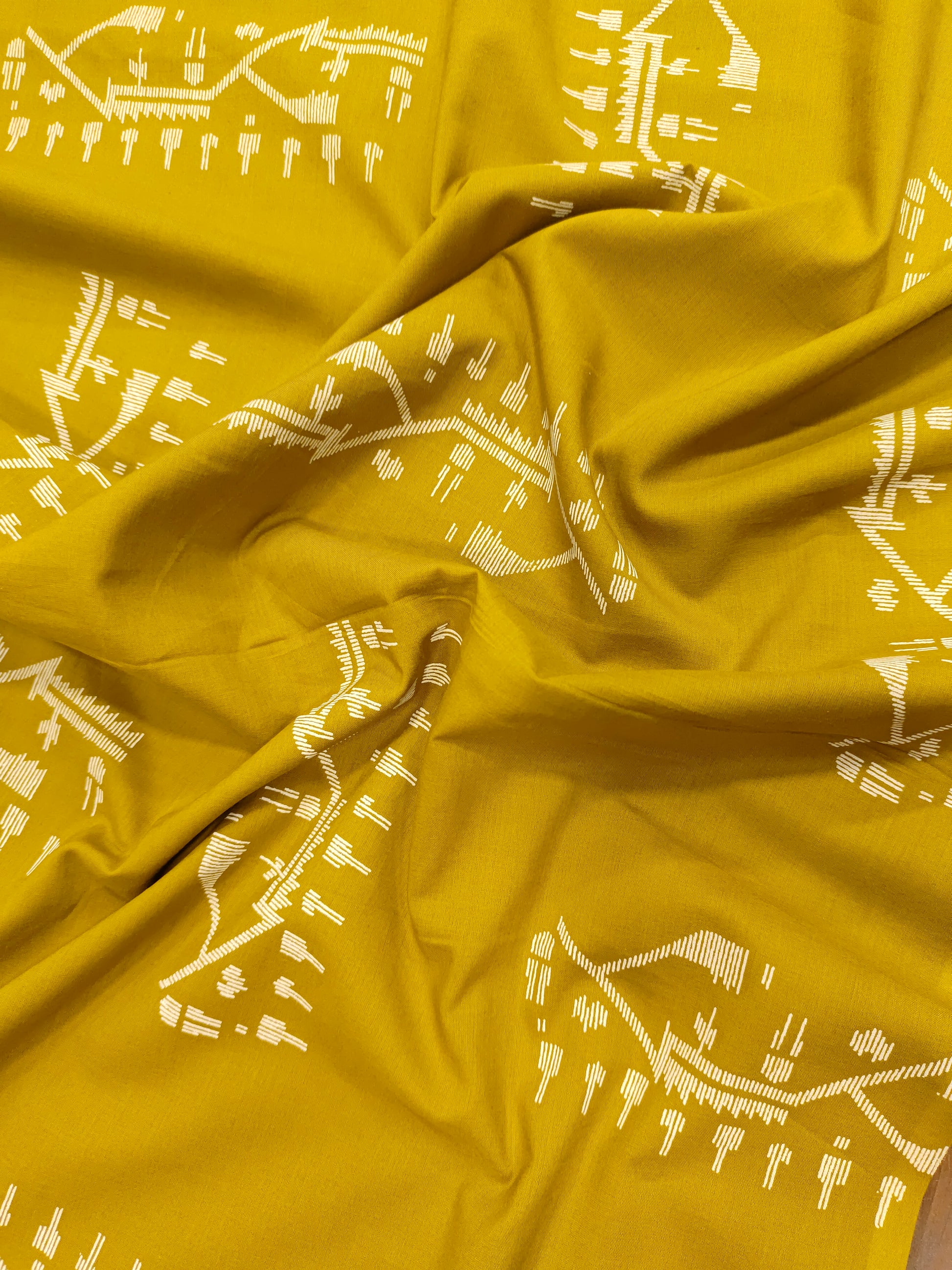 Mustard color cotton fabric with jamdani print in white.